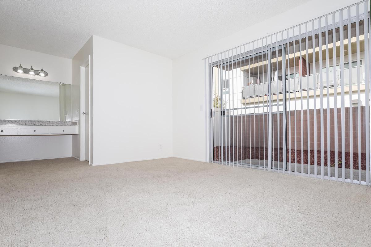 Carpeted room with sliding glass doors to patio