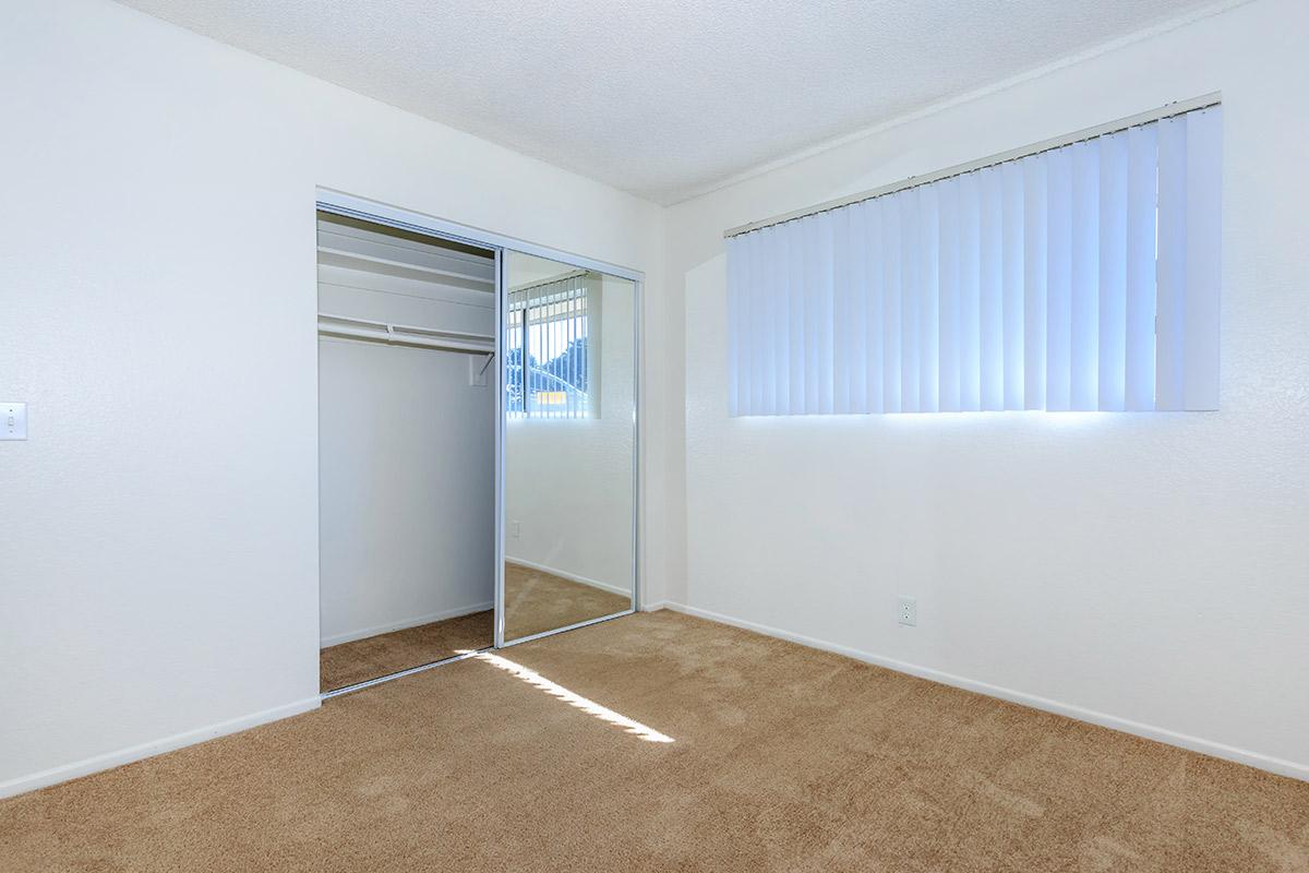 Bedroom with sliding mirror glass closet doors and carpet