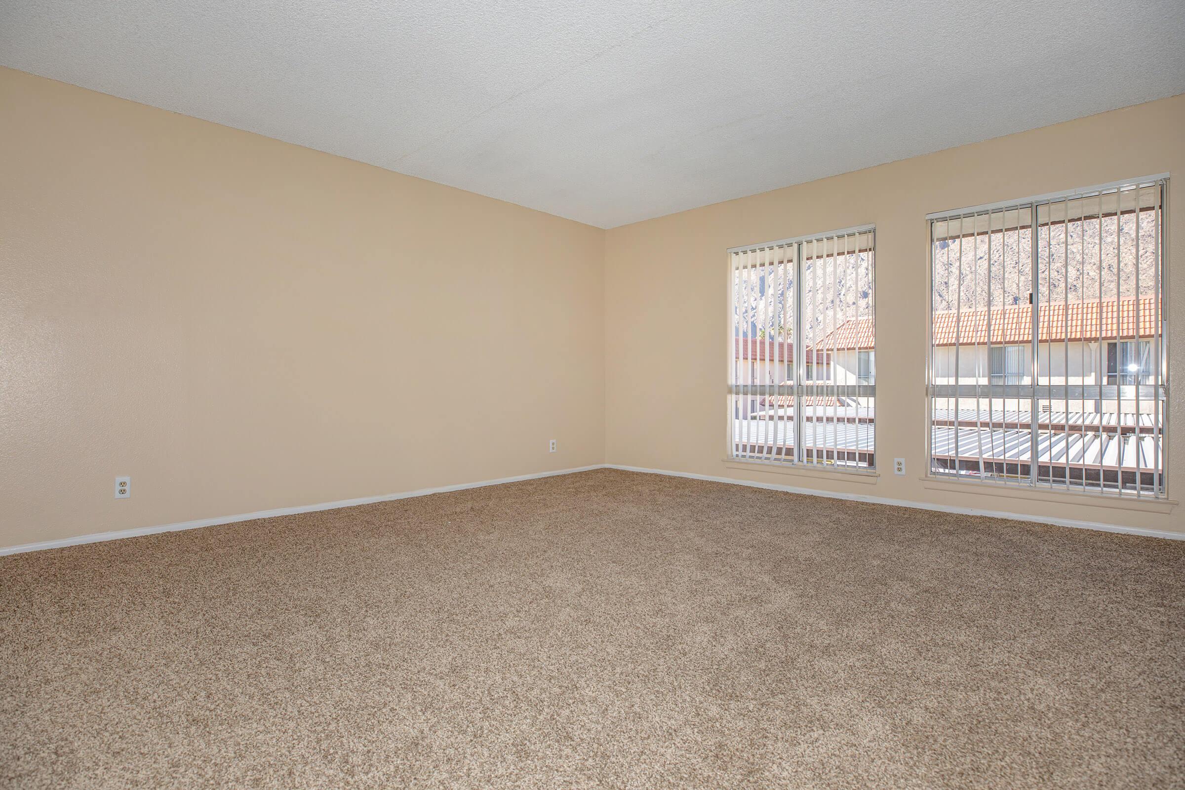 Carpeted living room with open window blinds