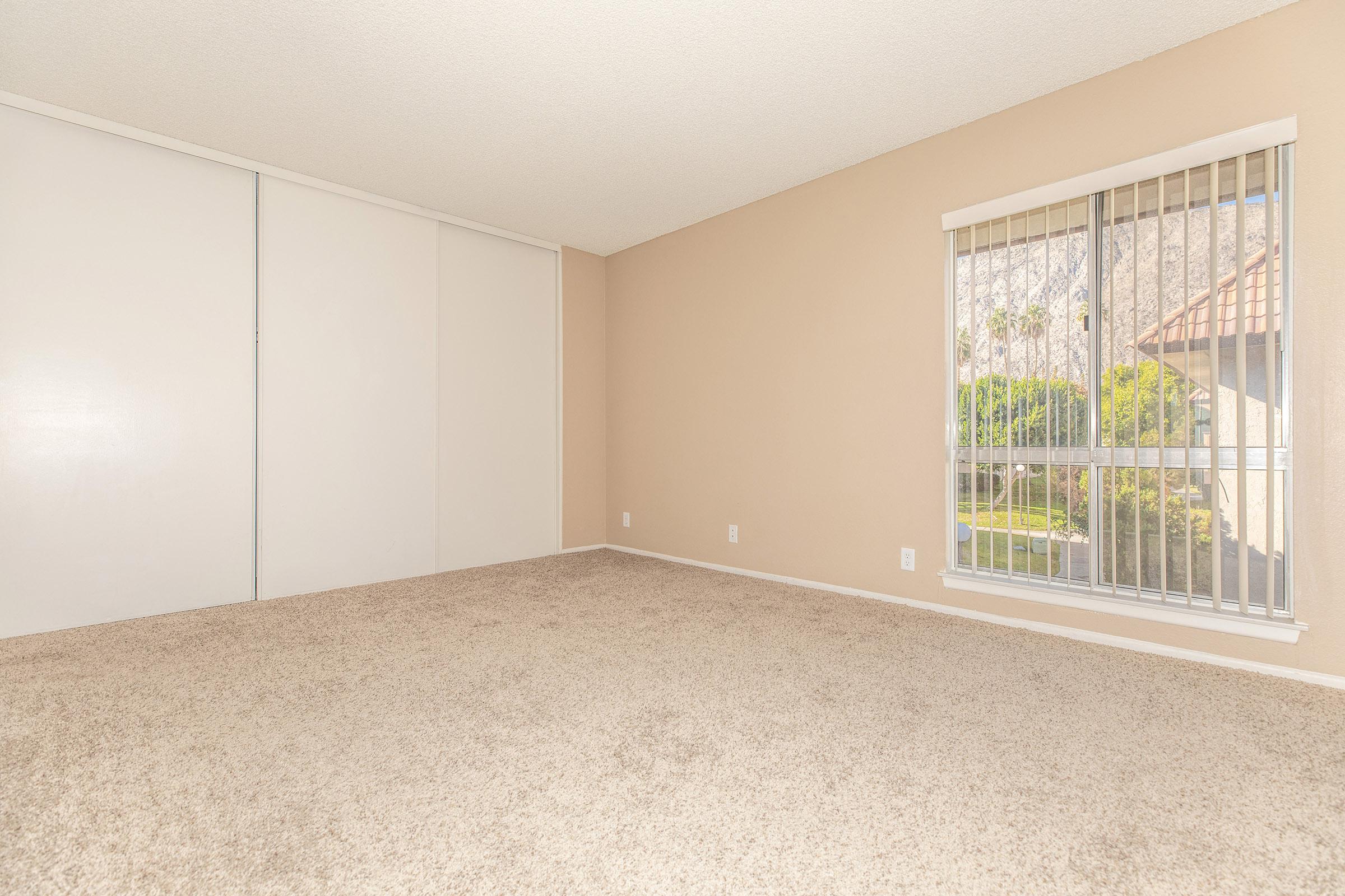 Carpeted bedroom with closed sliding closet doors