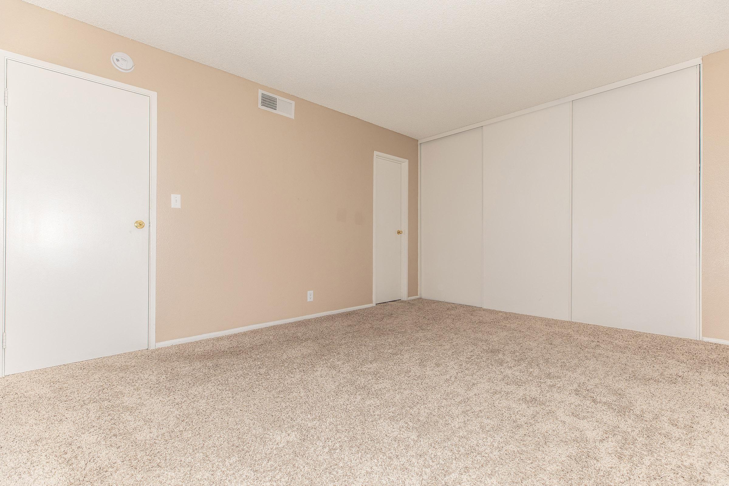 Carpeted bedroom with sliding closet doors