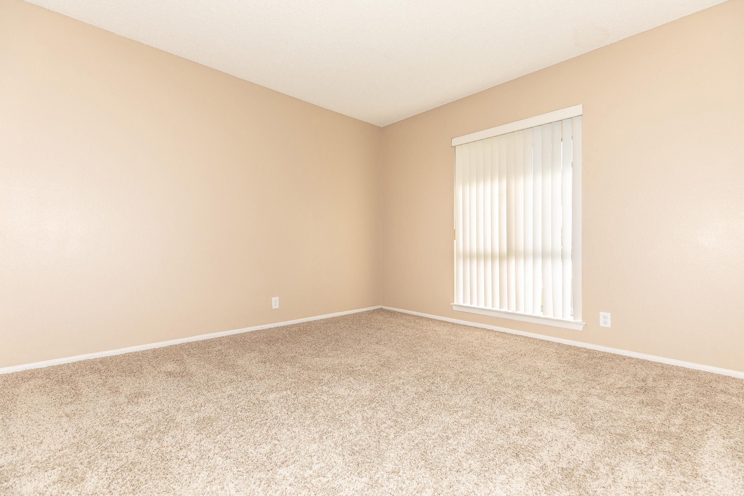 Unfurnished carpeted bedroom with window blinds