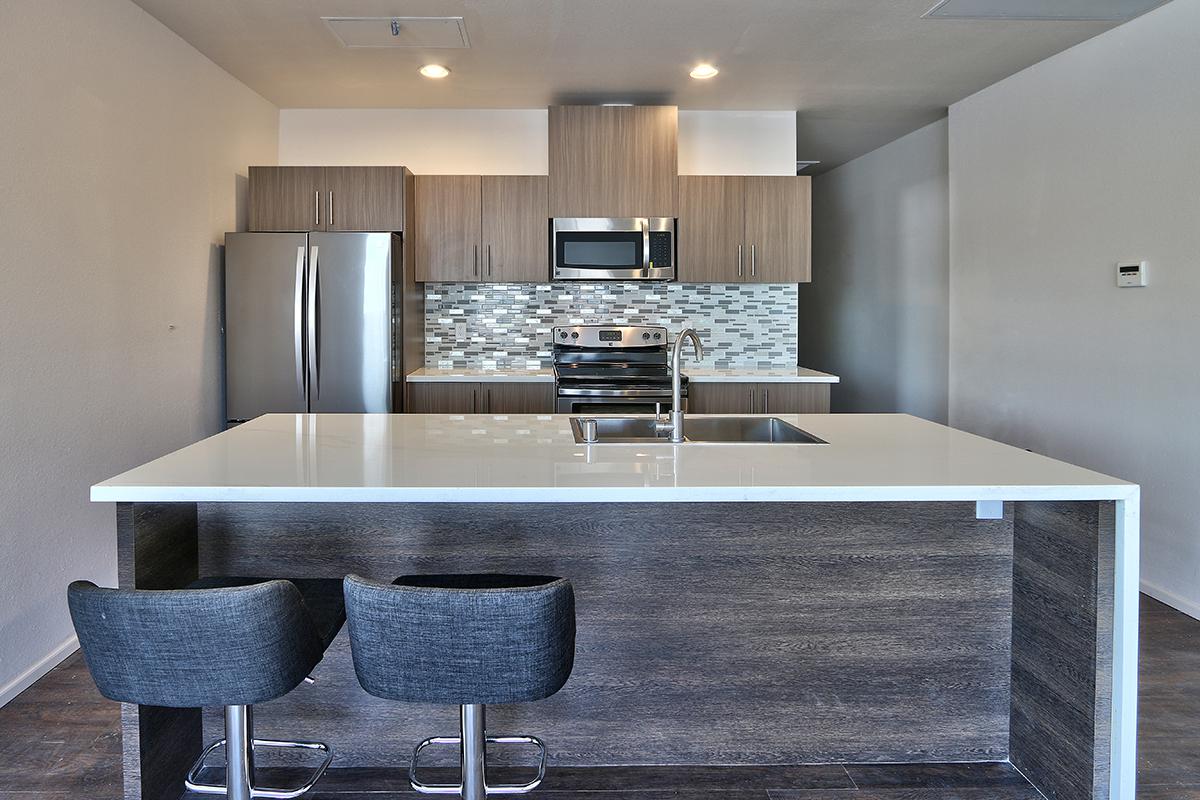 a modern kitchen with stainless steel appliances and wooden cabinets