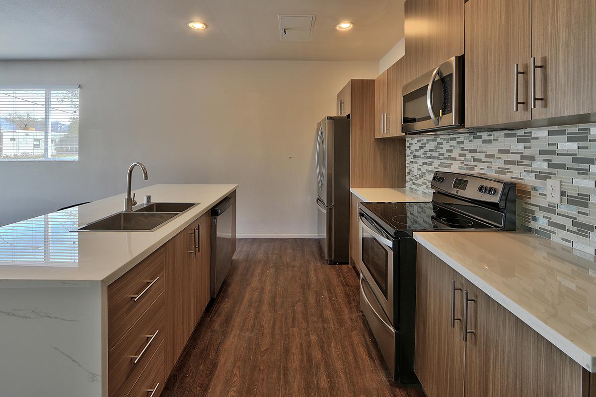 a modern kitchen with stainless steel appliances and wooden cabinets