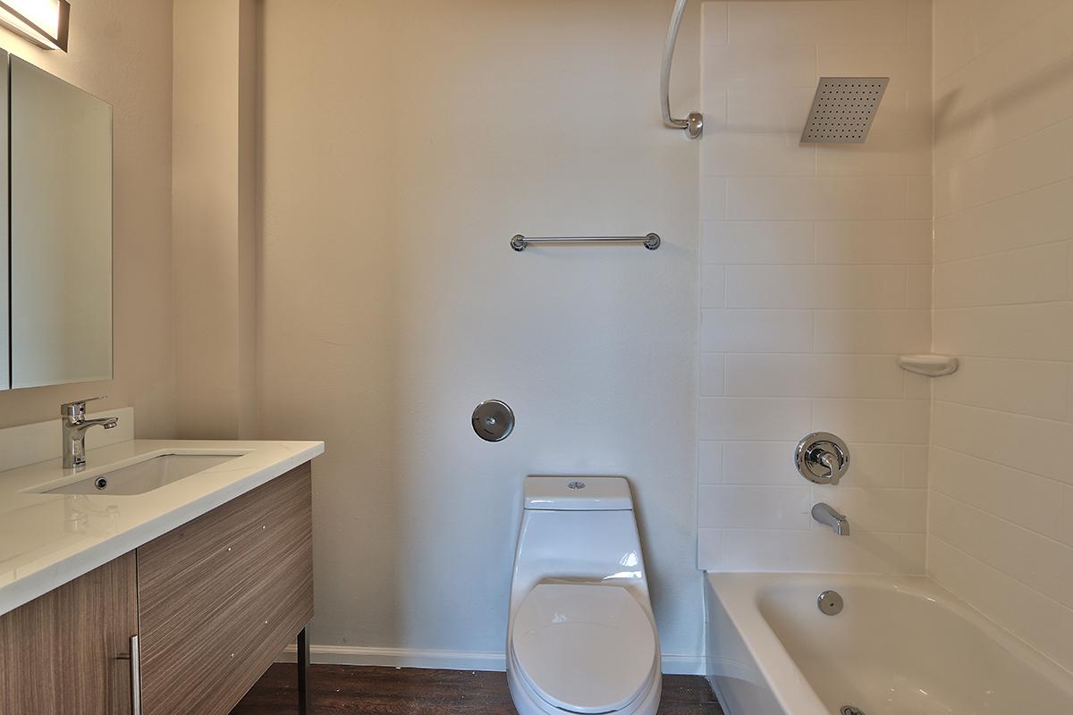 a white sink sitting under a mirror