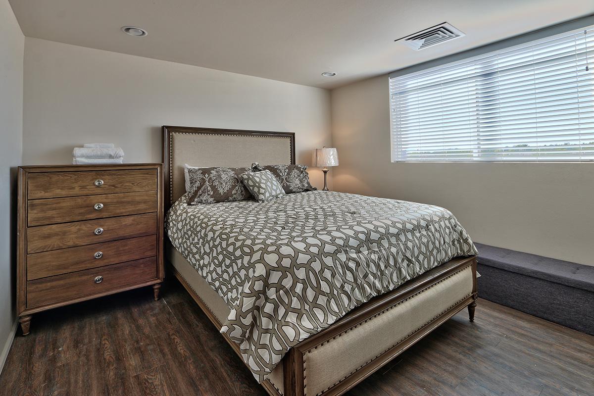 a bedroom with a bed and desk in a room