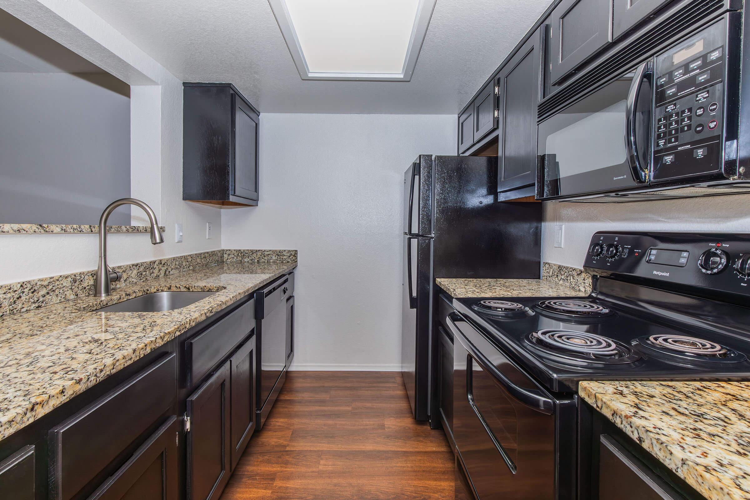 a large kitchen with stainless steel appliances and wooden cabinets