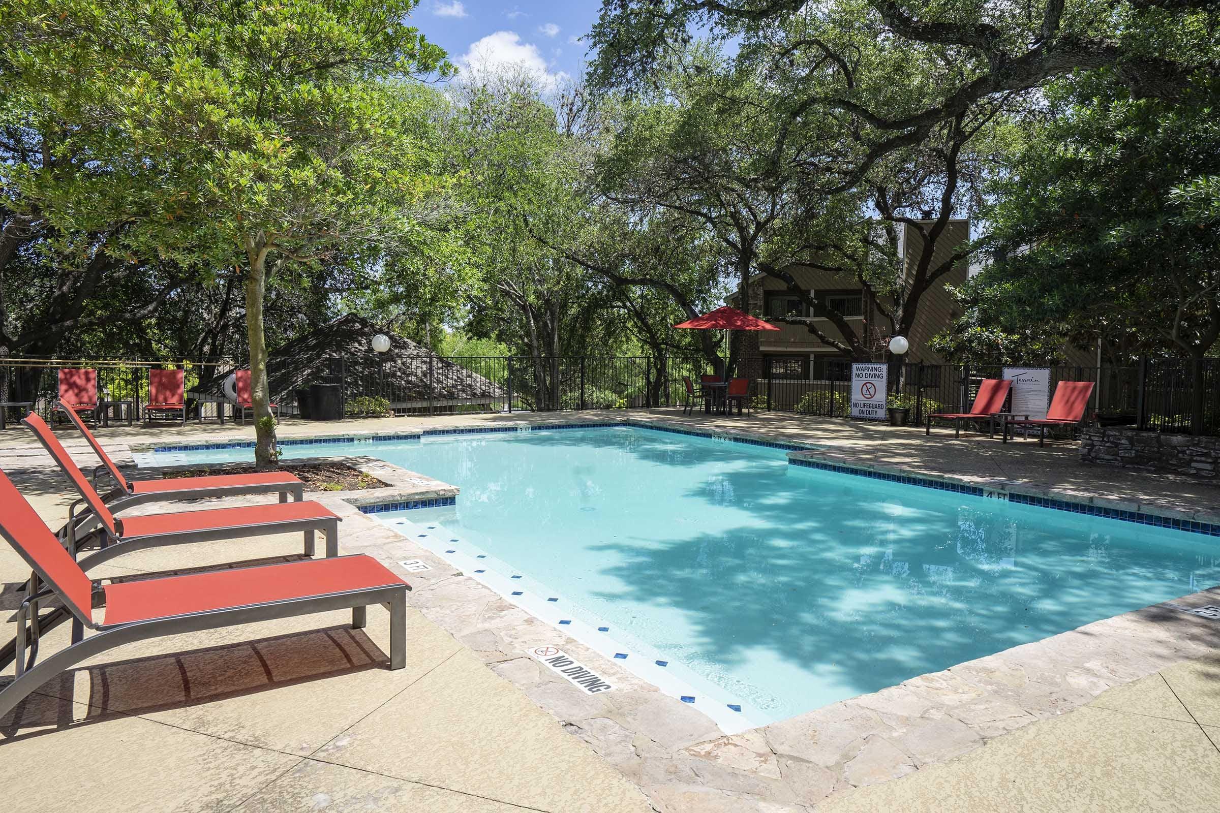 an empty park bench next to a pool of water