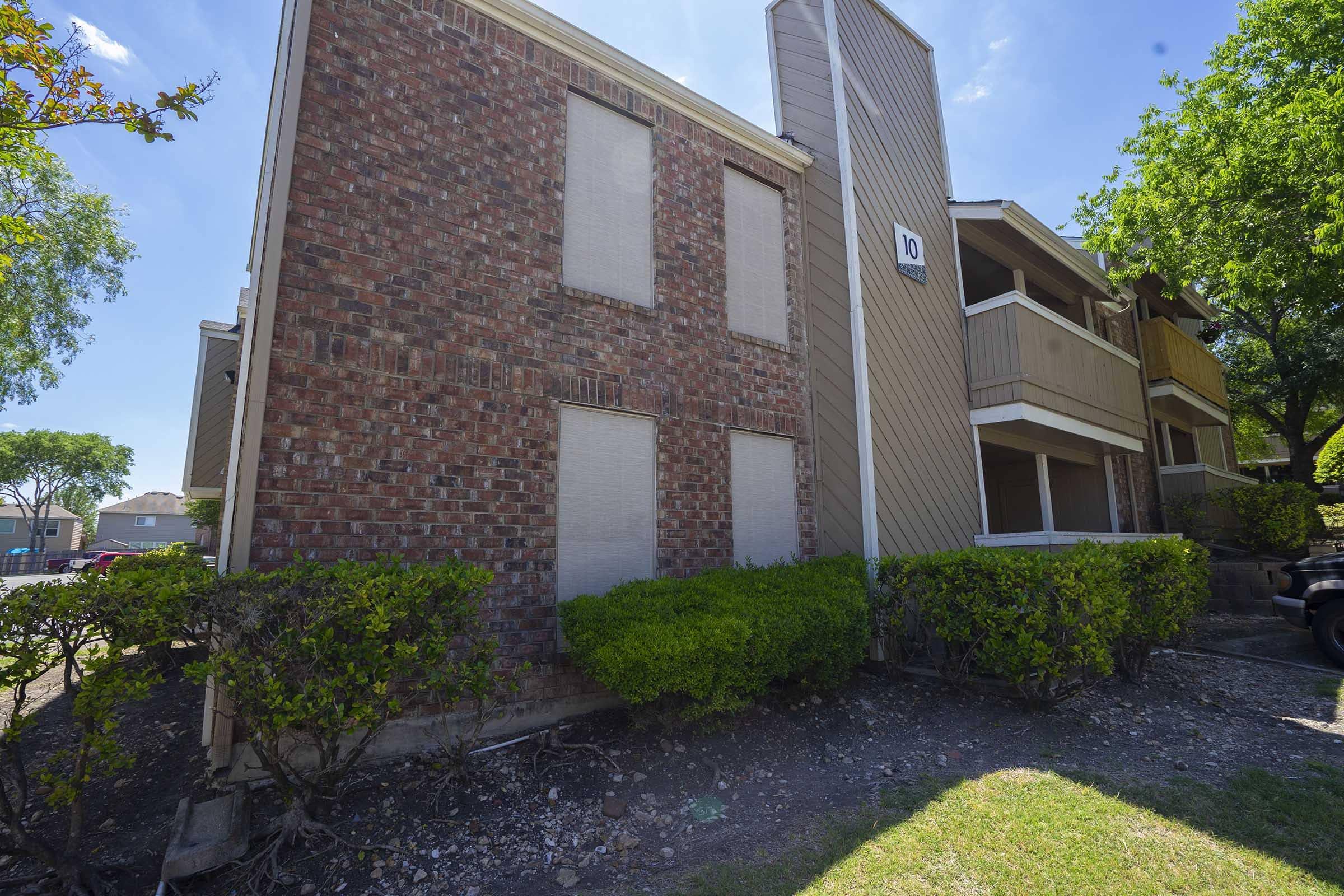 a large brick building with grass in front of a house