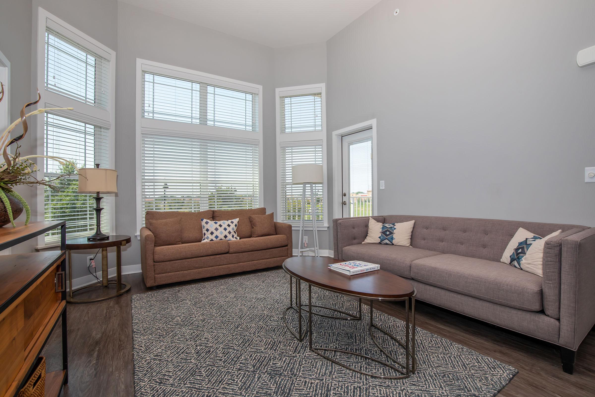 a living room filled with furniture and a large window