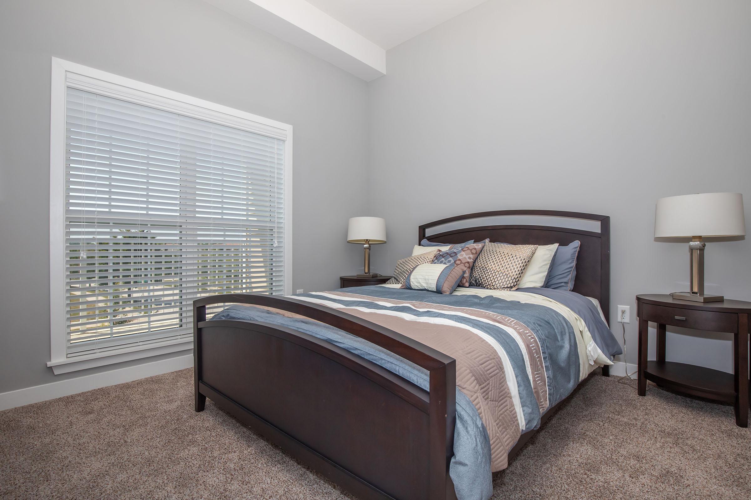 a bedroom with a bed and desk in a hotel room