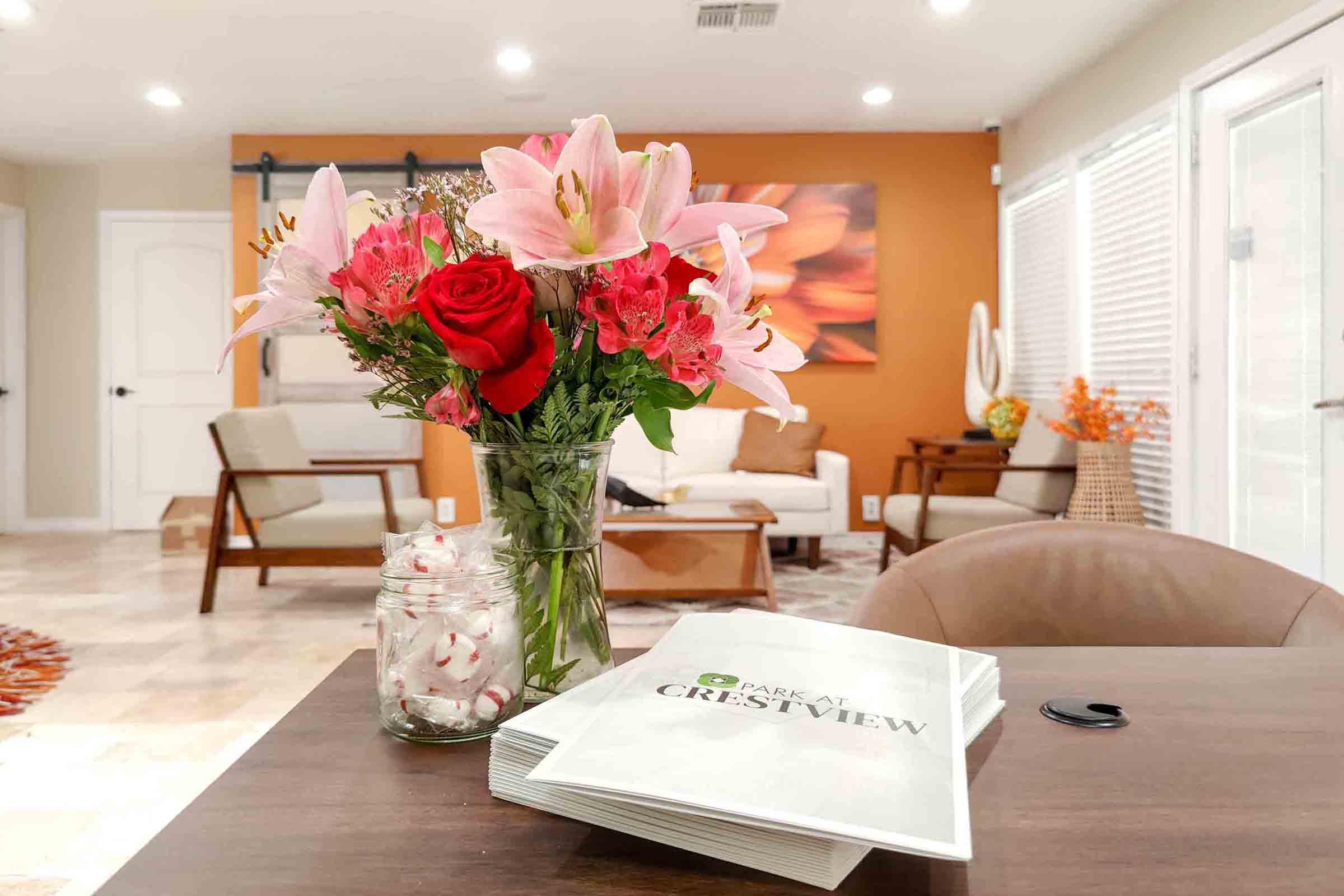 a living room filled with furniture and vase of flowers on a table
