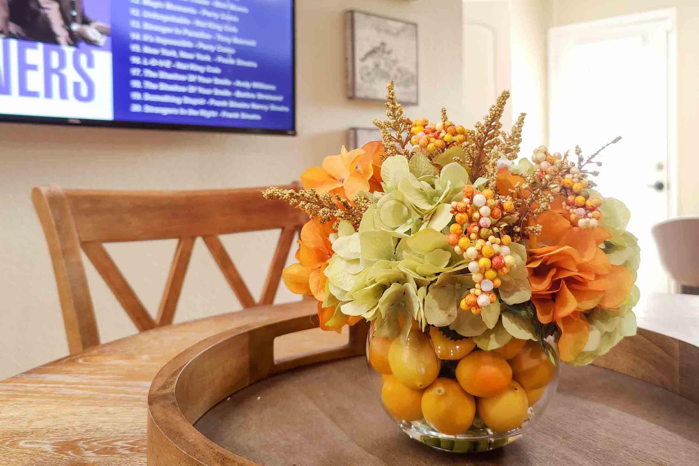 a vase of flowers sitting on top of a wooden table