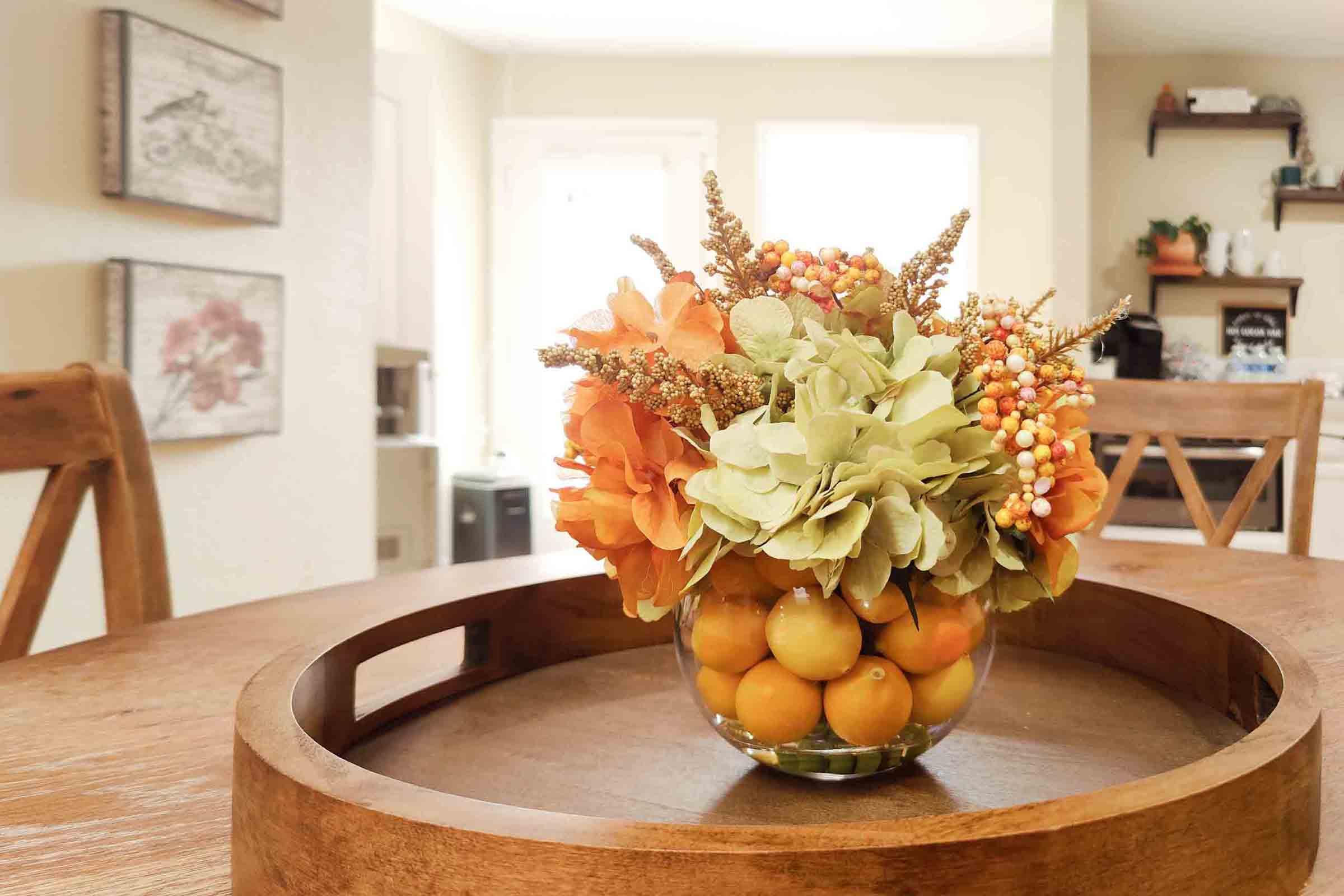 a vase filled with flowers sitting on top of a wooden table