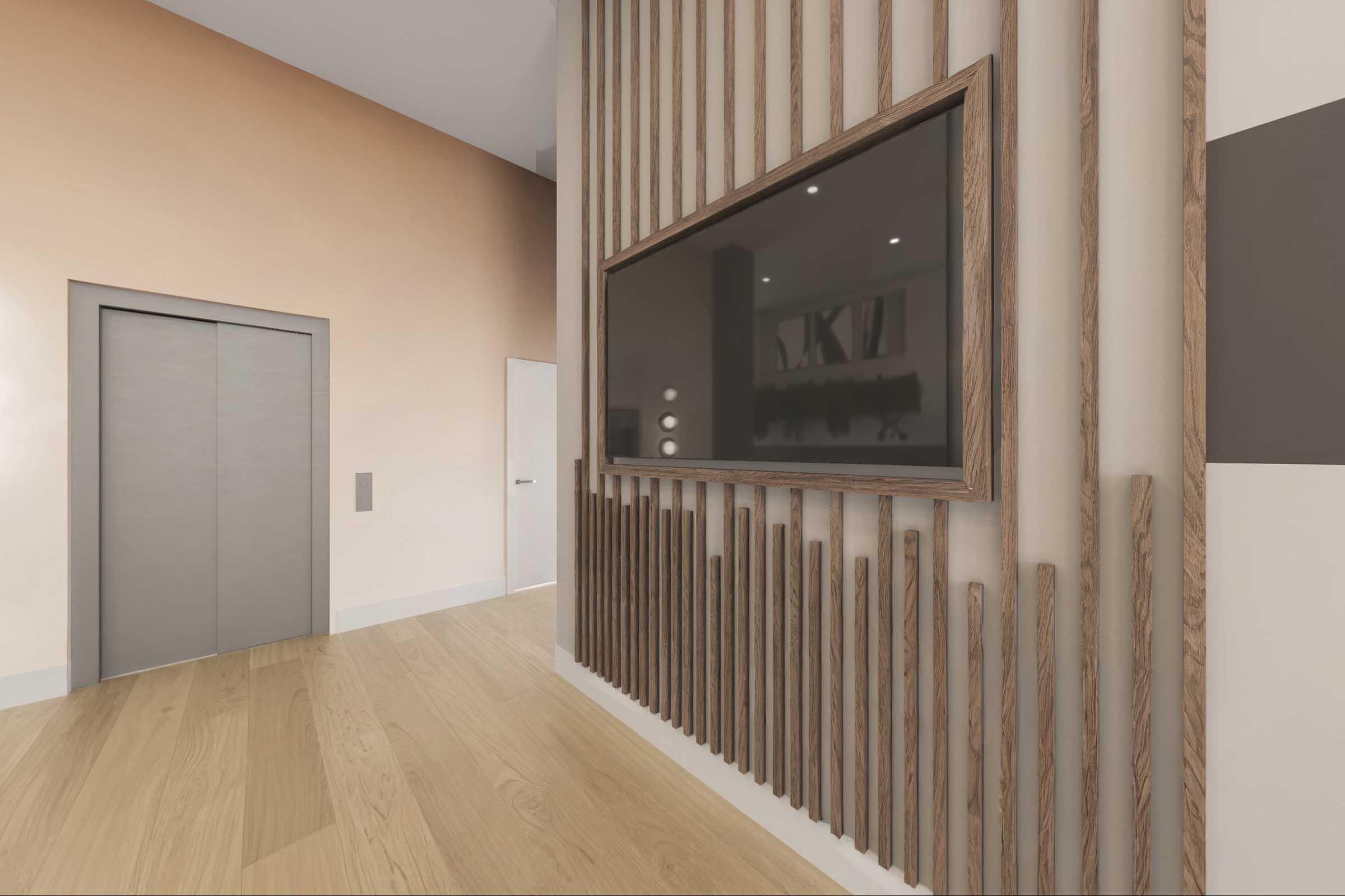 Interior view of a modern hallway featuring wooden accent walls and a large flat-screen TV mounted on the wall. A silver elevator door is visible on the left, and the floor is made of light-colored wood. The walls are painted in warm tones, creating a stylish and inviting atmosphere.