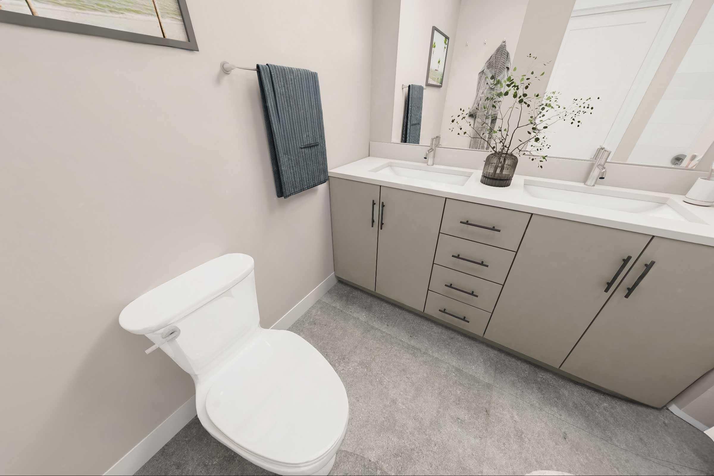 A modern bathroom featuring a white toilet, a dual-sink vanity with a gray cabinet, and a mirror above the sinks. There are two towels hanging on a towel bar, and a vase with greenery on the countertop adds a touch of decor. The floor is light gray, contributing to a clean and contemporary aesthetic.