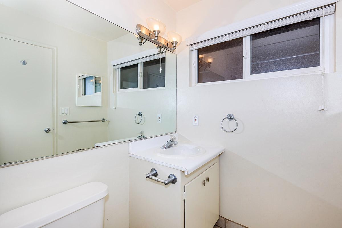 a white sink sitting under a mirror