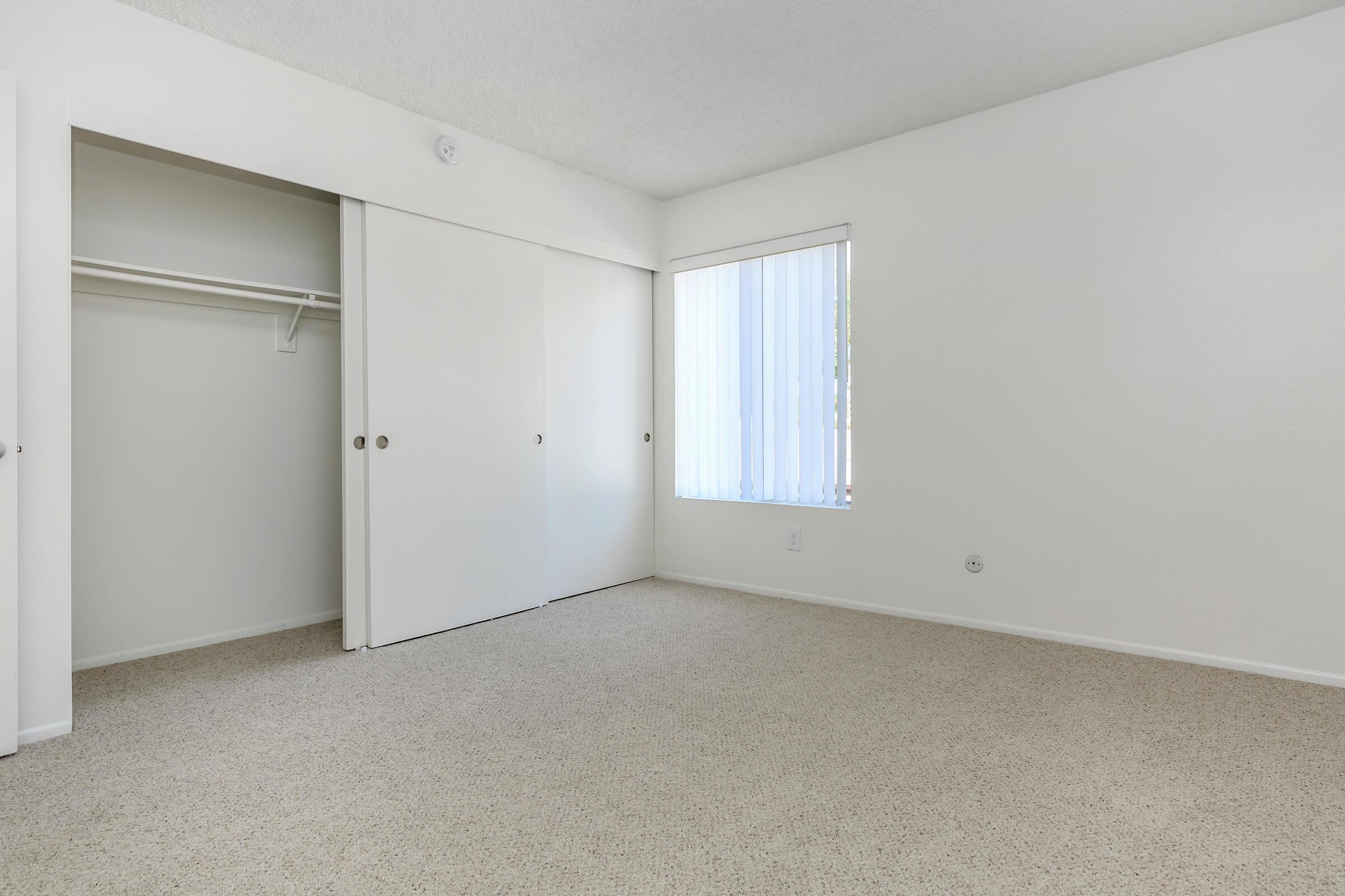 Carpeted bedroom with open sliding closet door