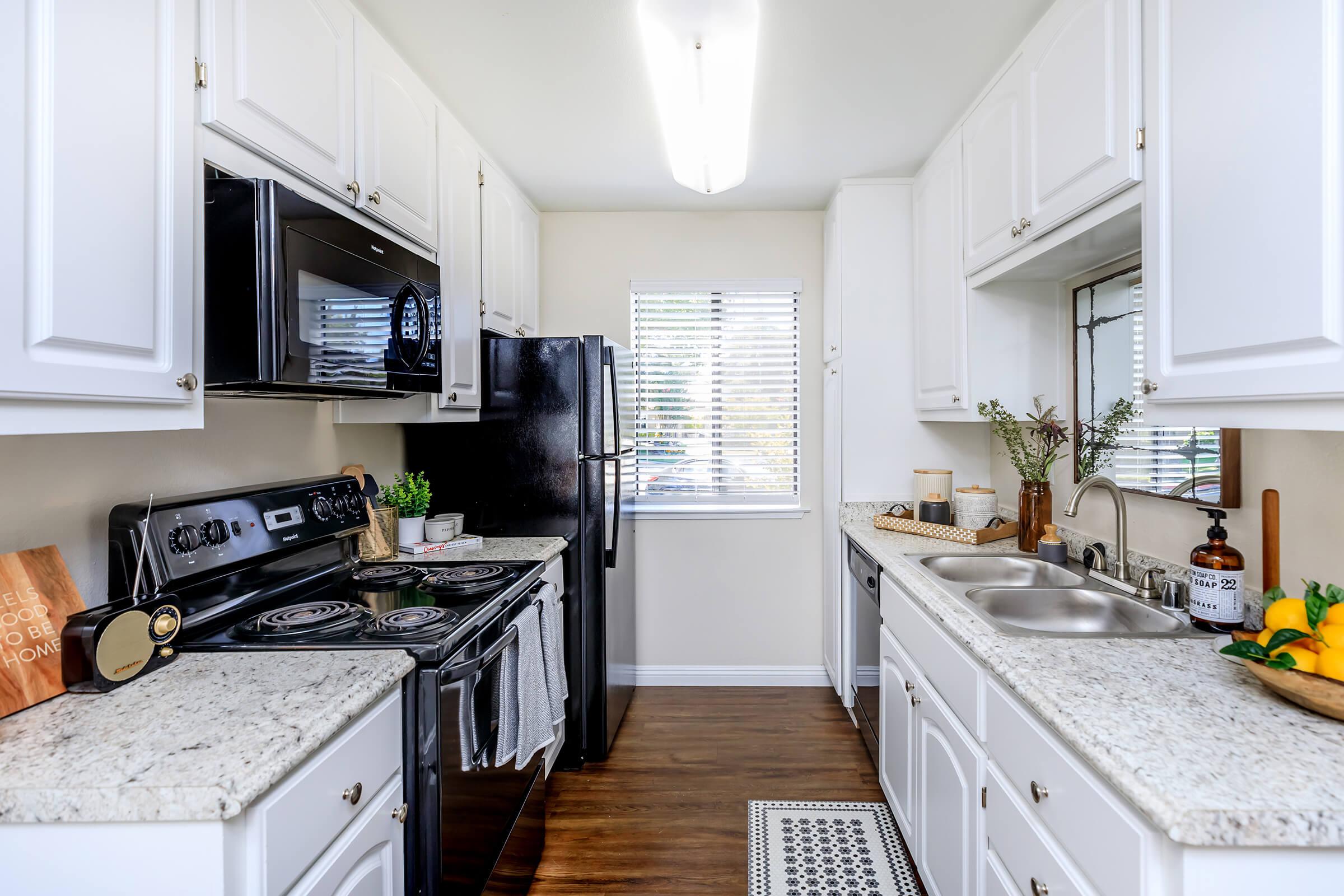 a kitchen with a stove a sink and a window