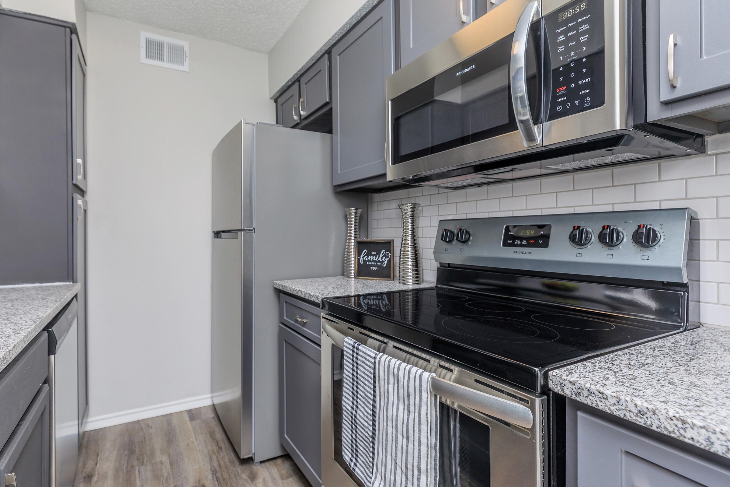 a stove top oven sitting inside of a kitchen with stainless steel appliances