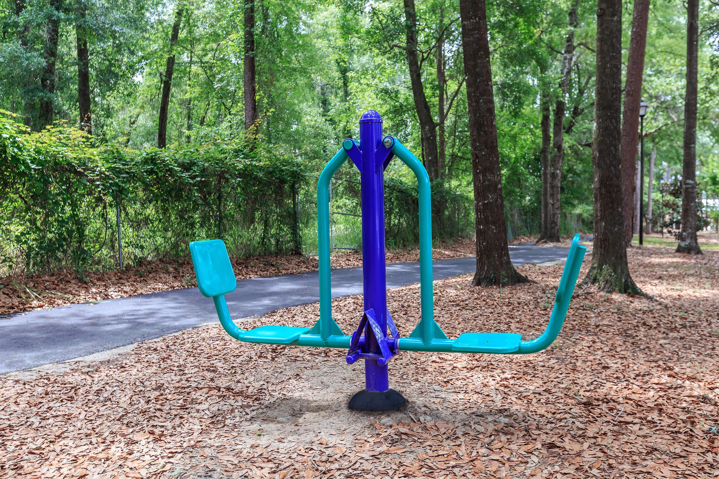 a blue bench in front of a forest