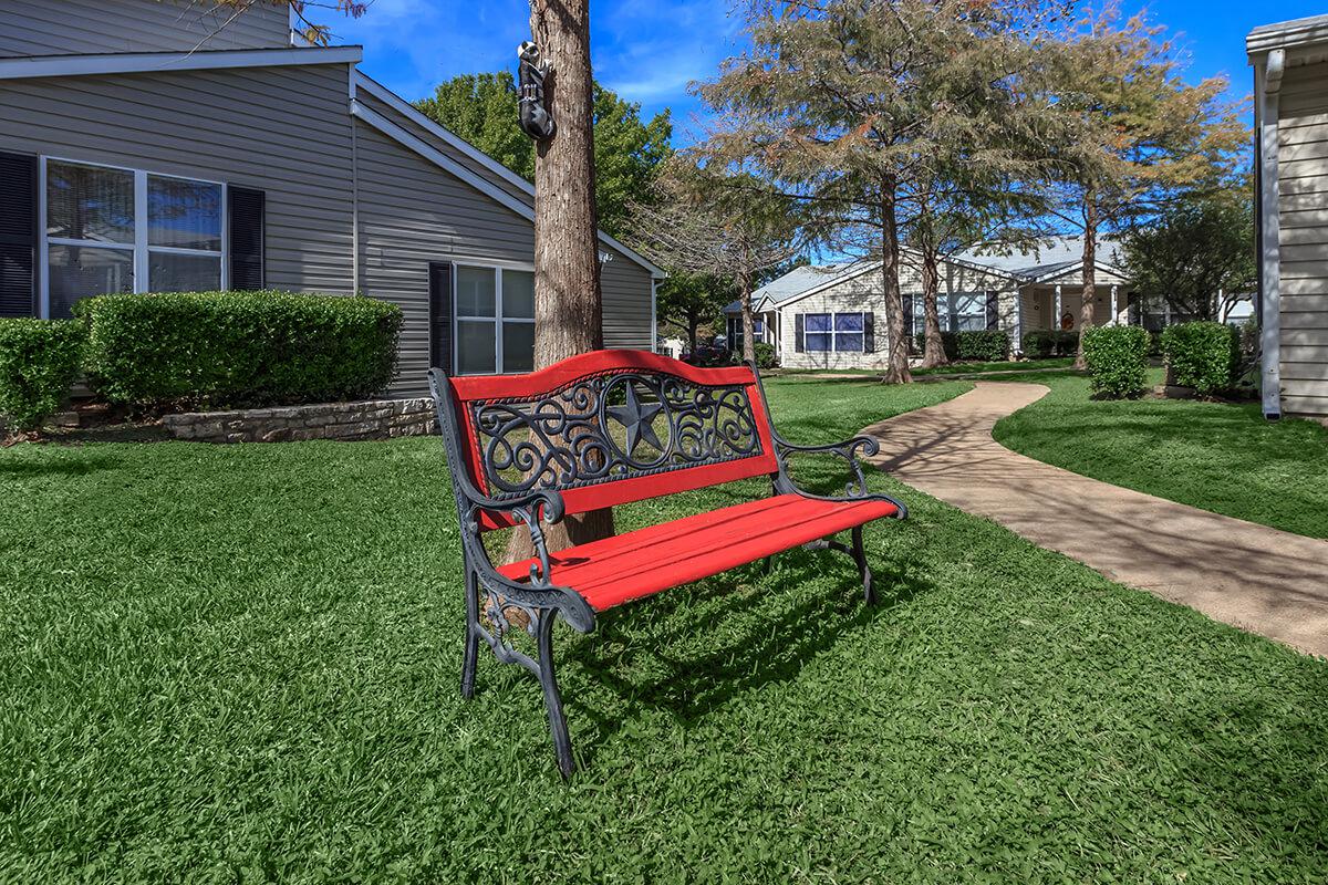 a couple of lawn chairs sitting on top of a grass covered field
