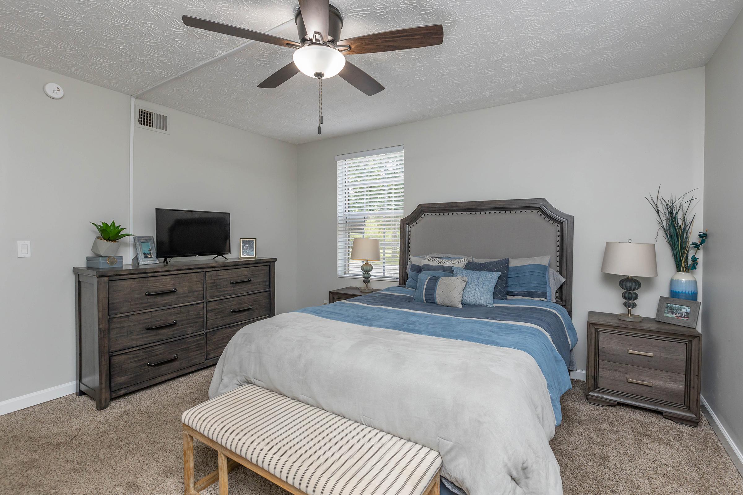 a bedroom with a bed and desk in a room