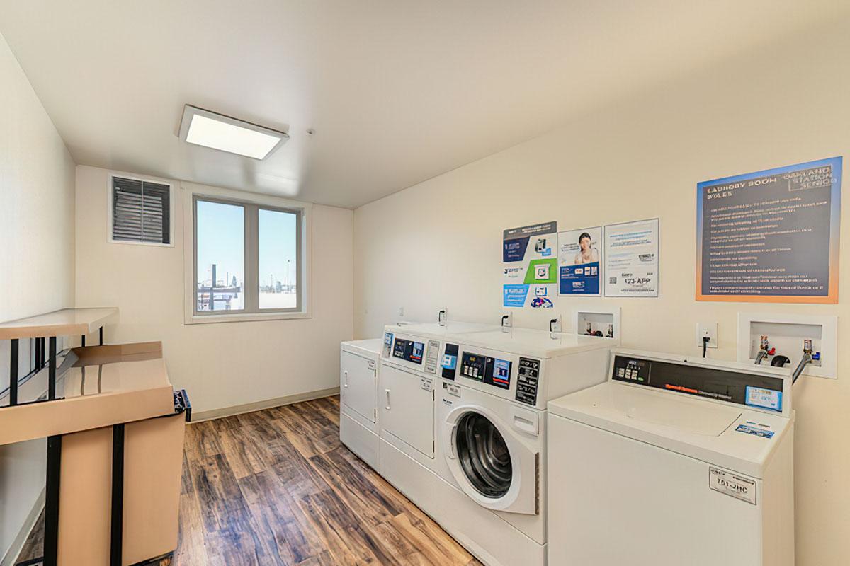 A clean and well-lit laundry room featuring several washing machines and dryers.
