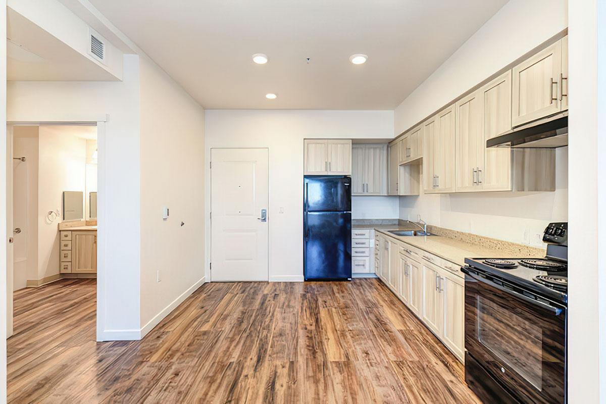 A modern kitchen featuring light-colored cabinets, a black refrigerator, and a black stove.