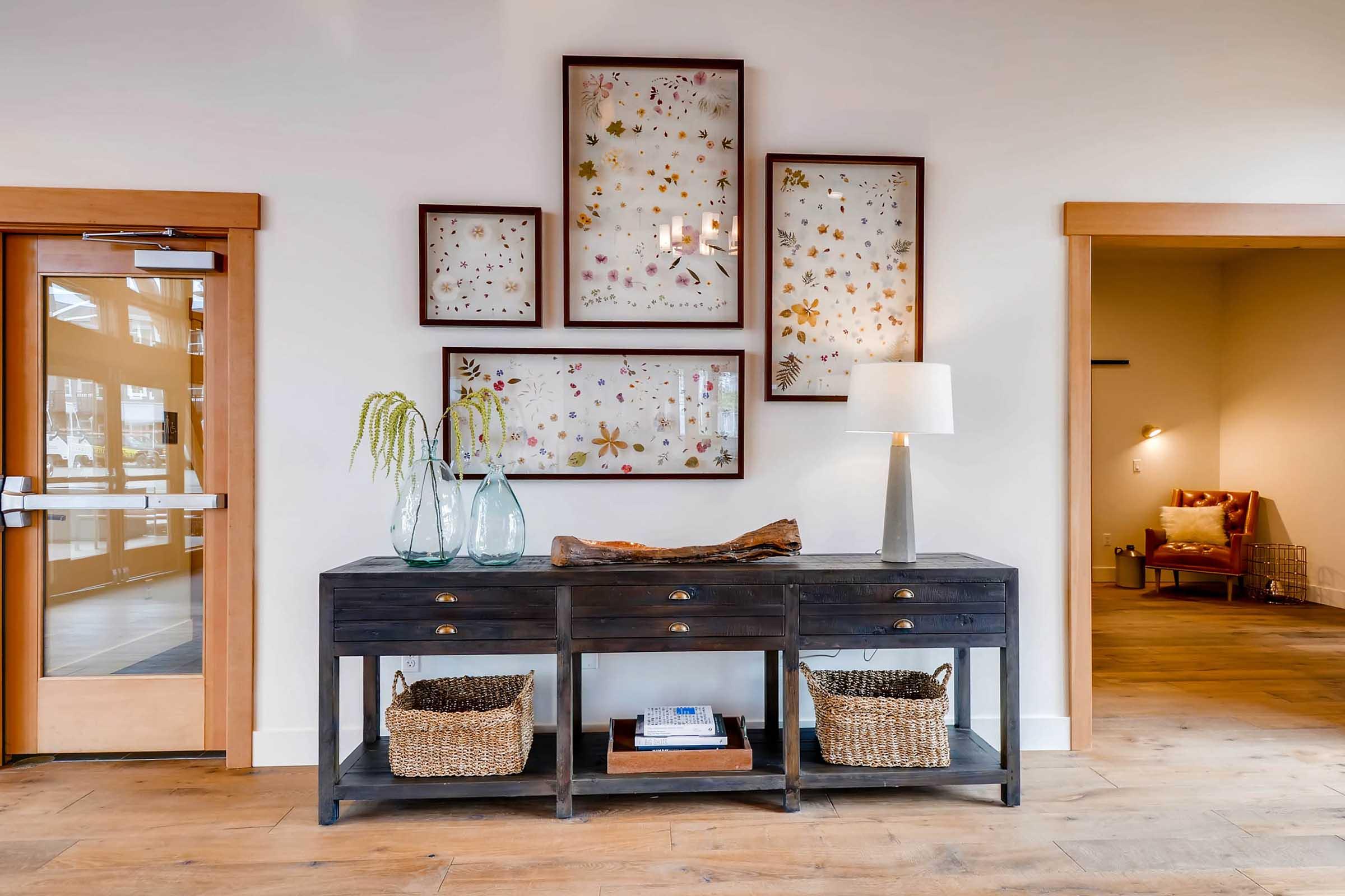 A stylish interior space featuring a dark wooden console table with decorative baskets underneath.