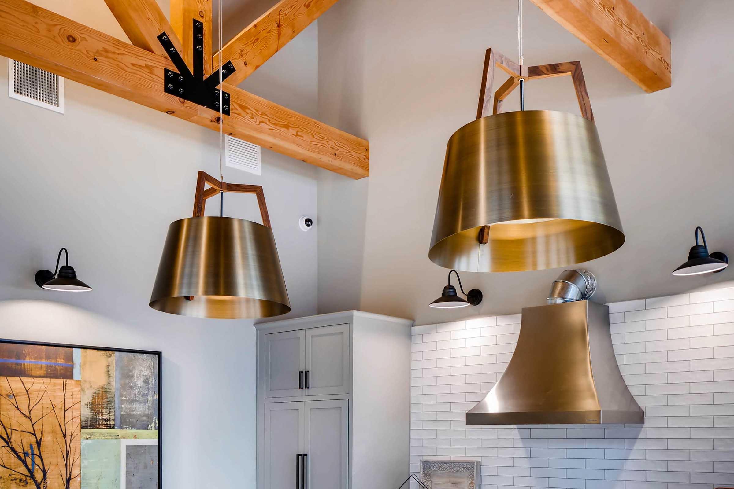 Three large, stylish pendant lights with a brass finish hang from the ceiling, showcasing a modern design.