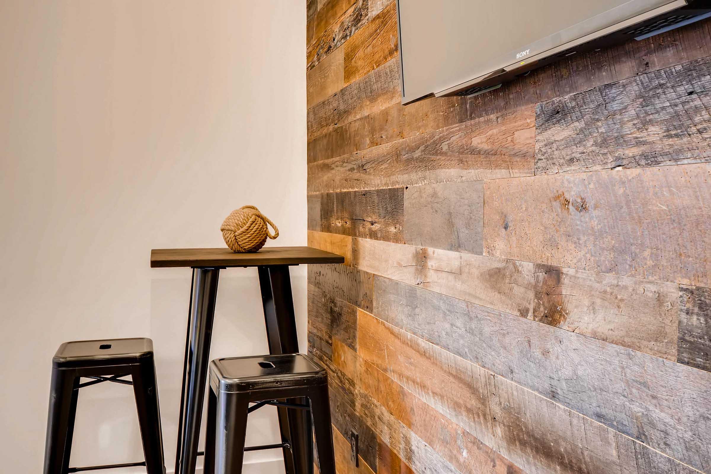 A cozy corner featuring a wooden wall with a mix of light and dark planks.