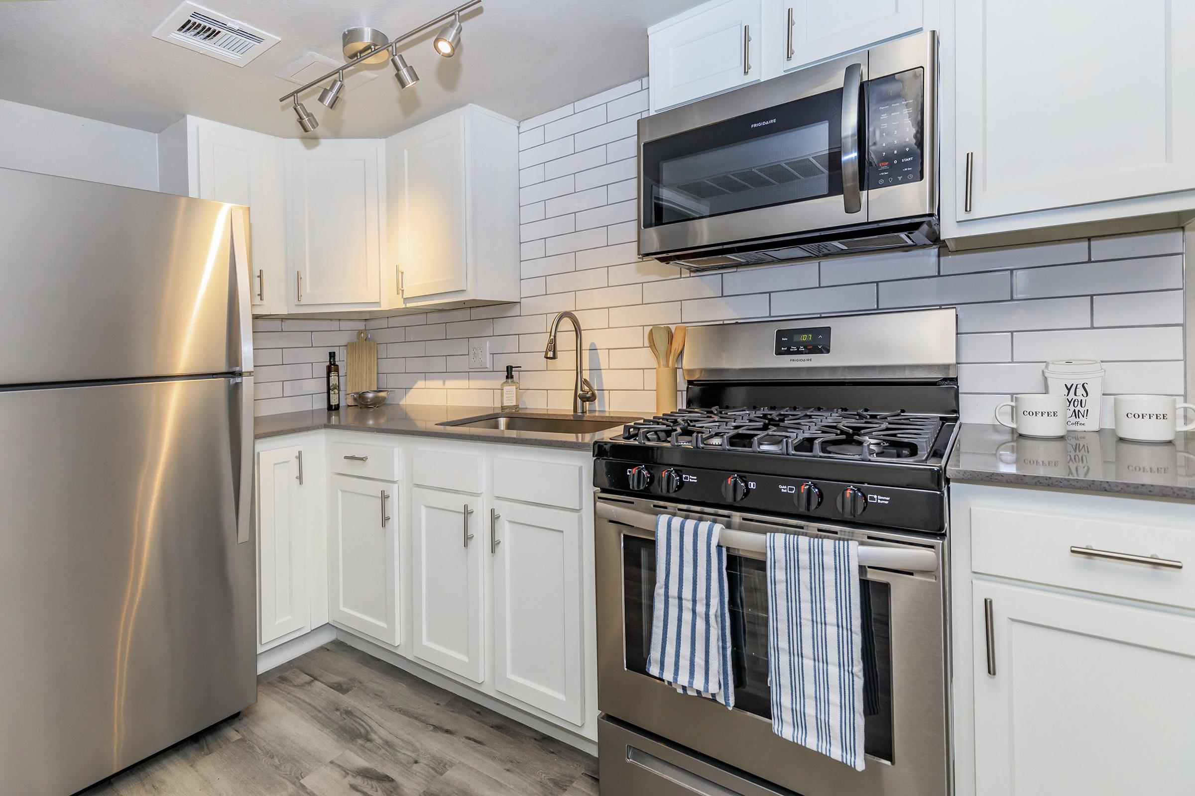 a stove top oven sitting inside of a kitchen