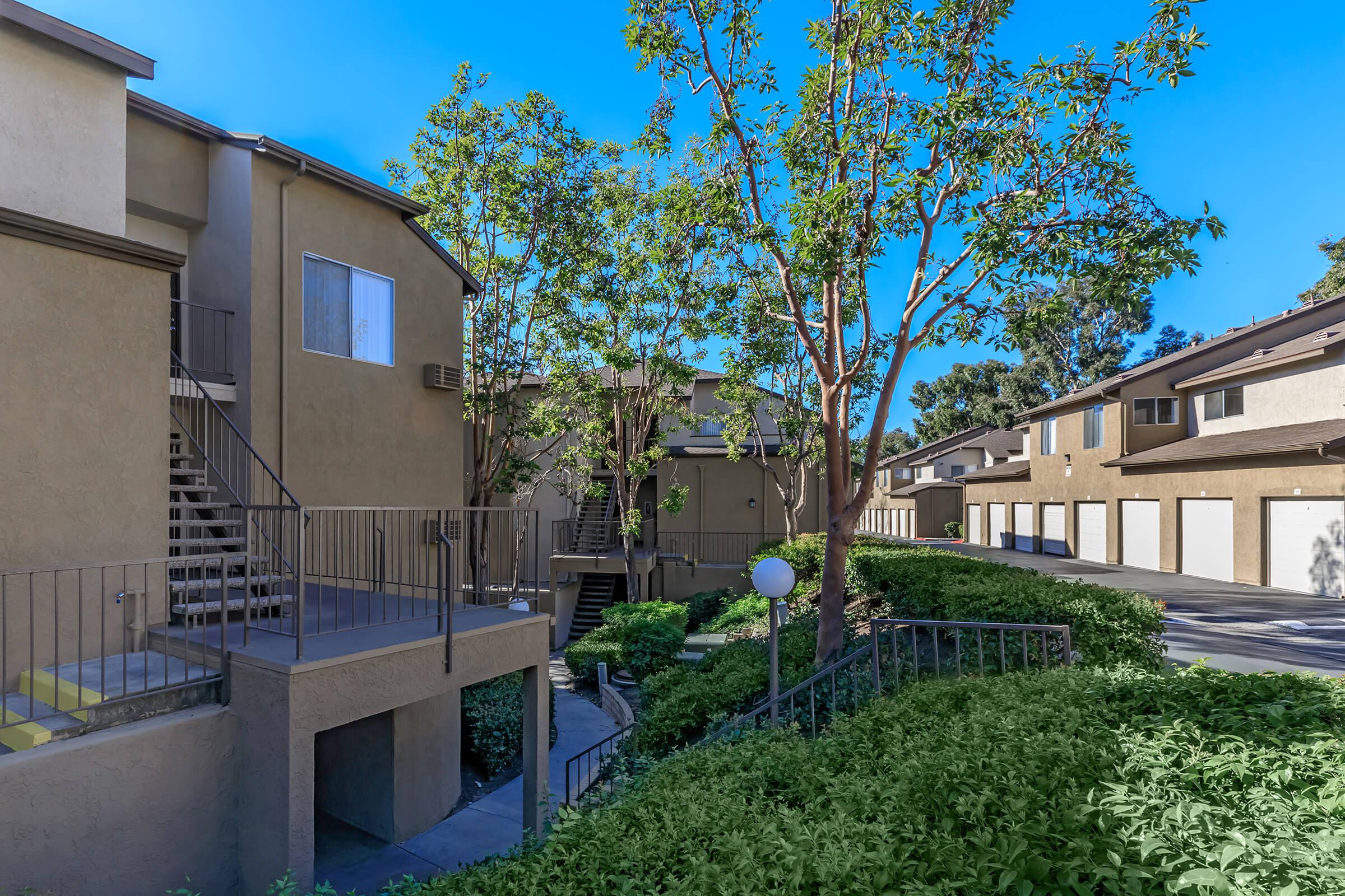 Trabuco Woods Apartment Homes community buildings with green shrubs