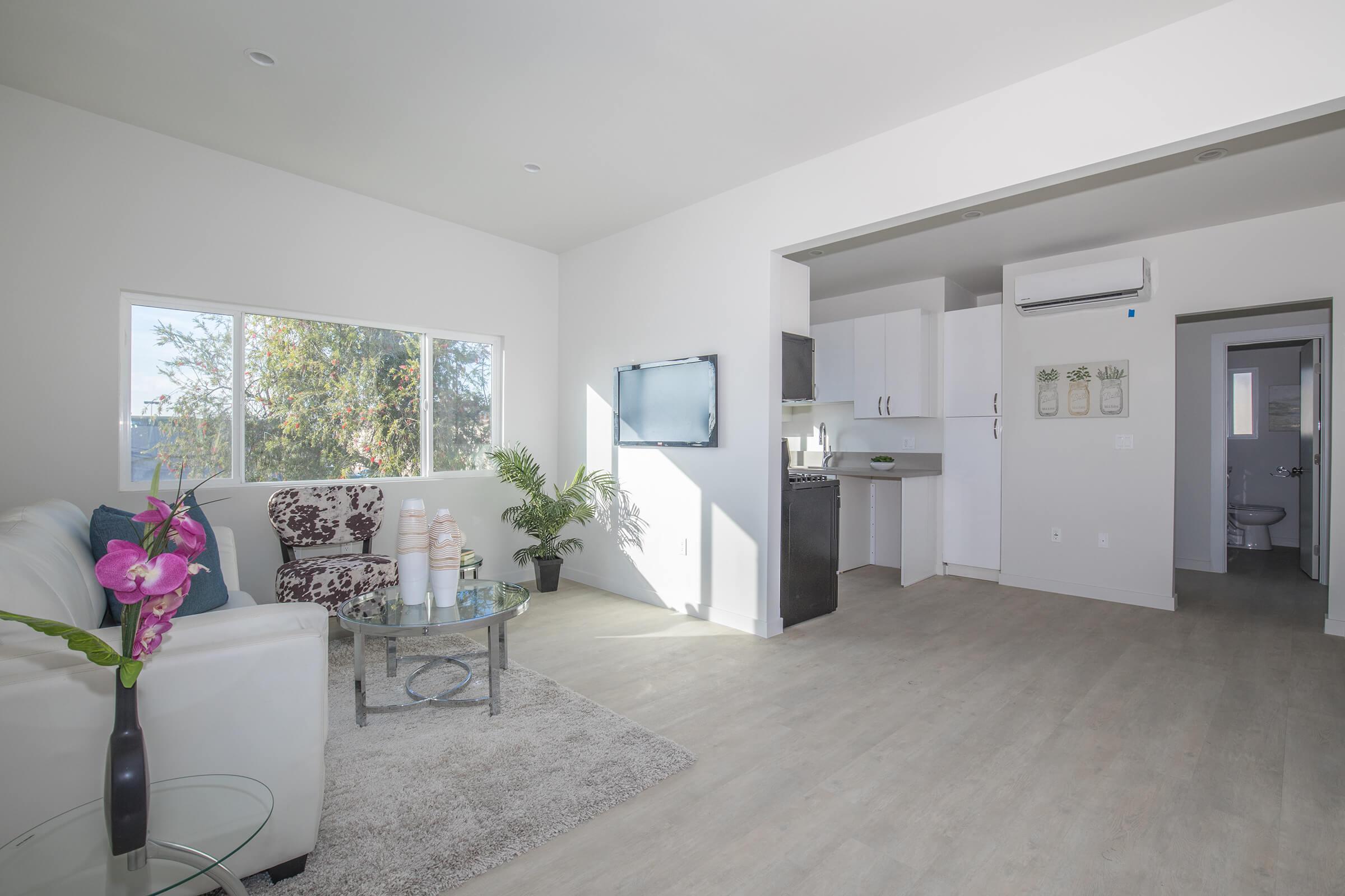 a living room filled with furniture and a large window