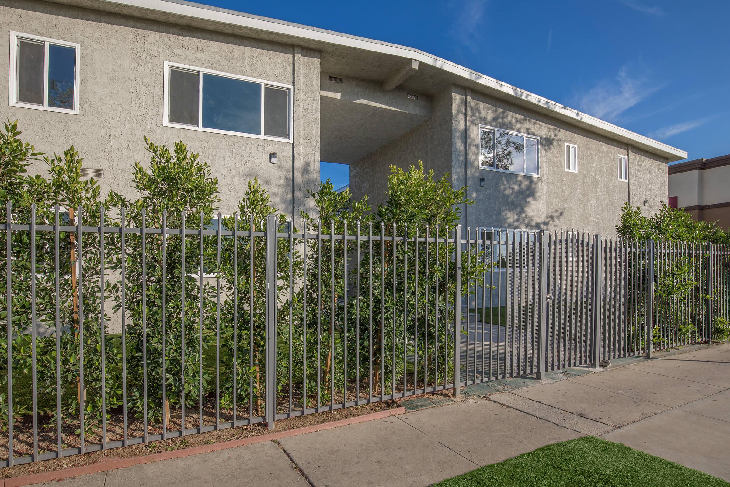 a house with a fence in front of a building