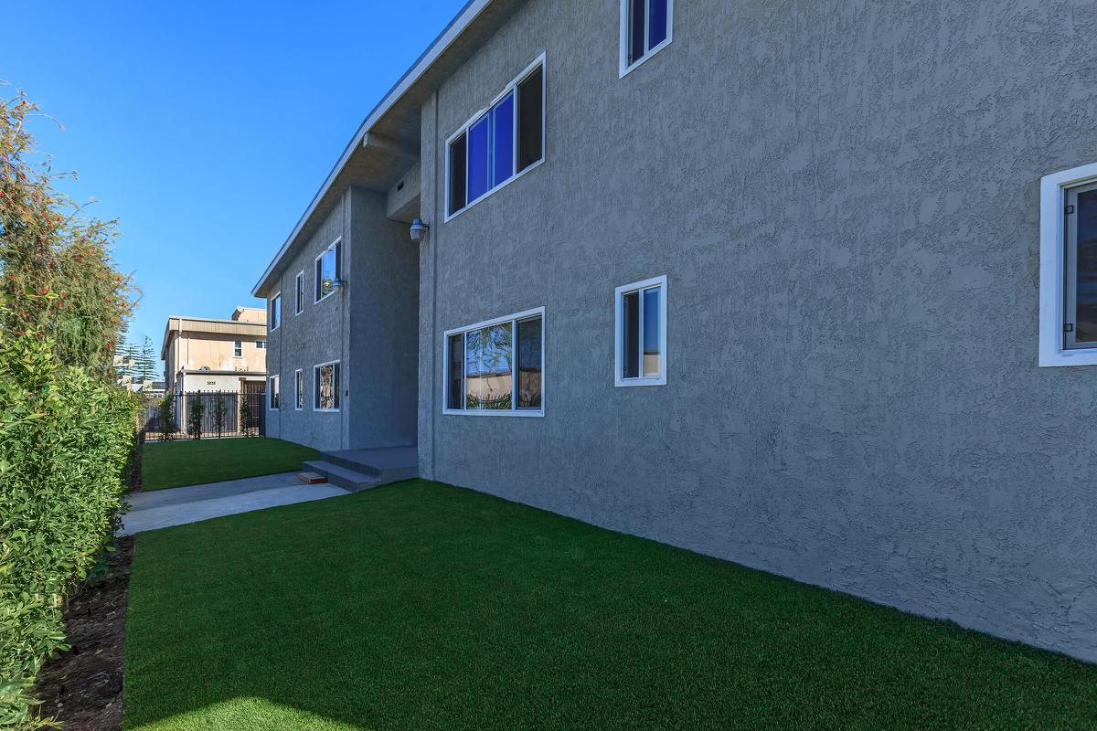 a large brick building with grass in front of a house