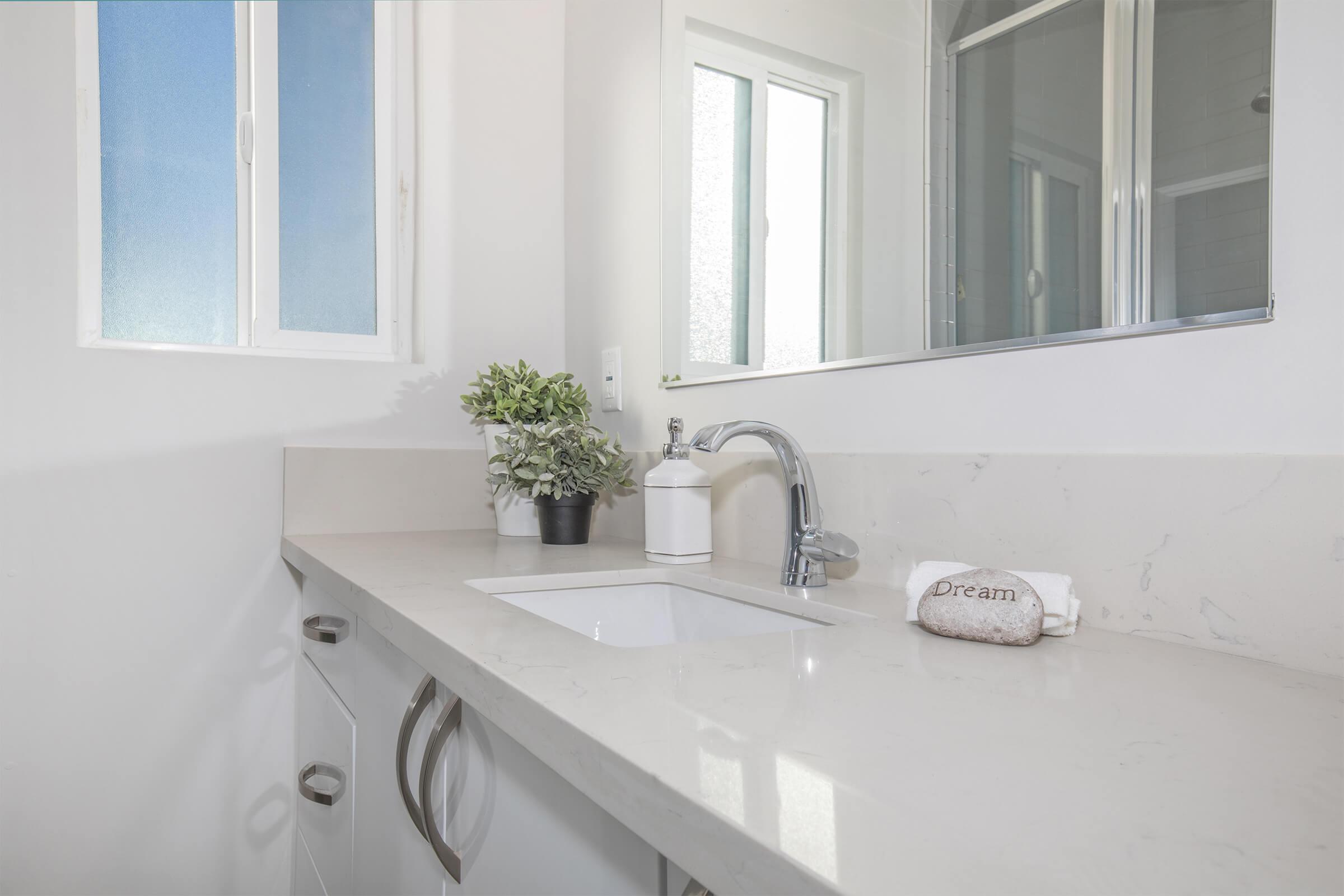 a white sink sitting under a window