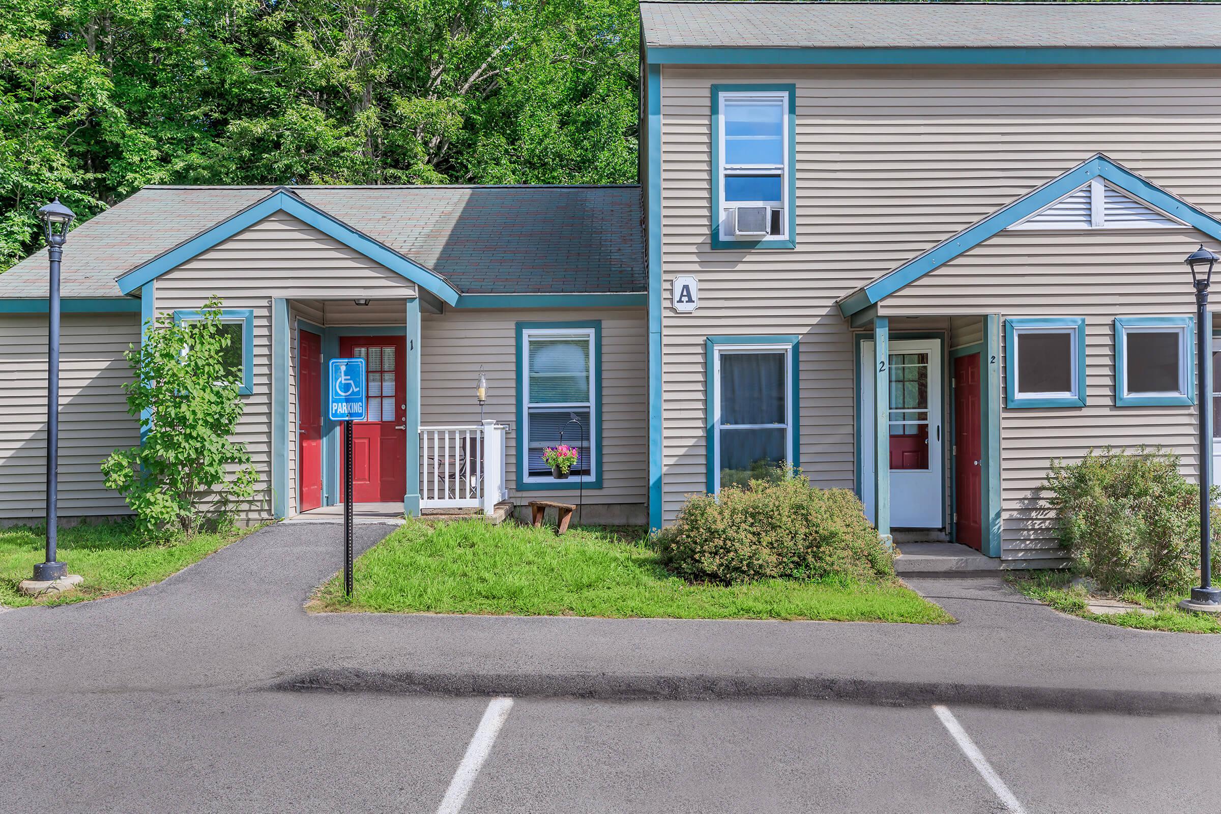 a house that has a sign on the side of a road