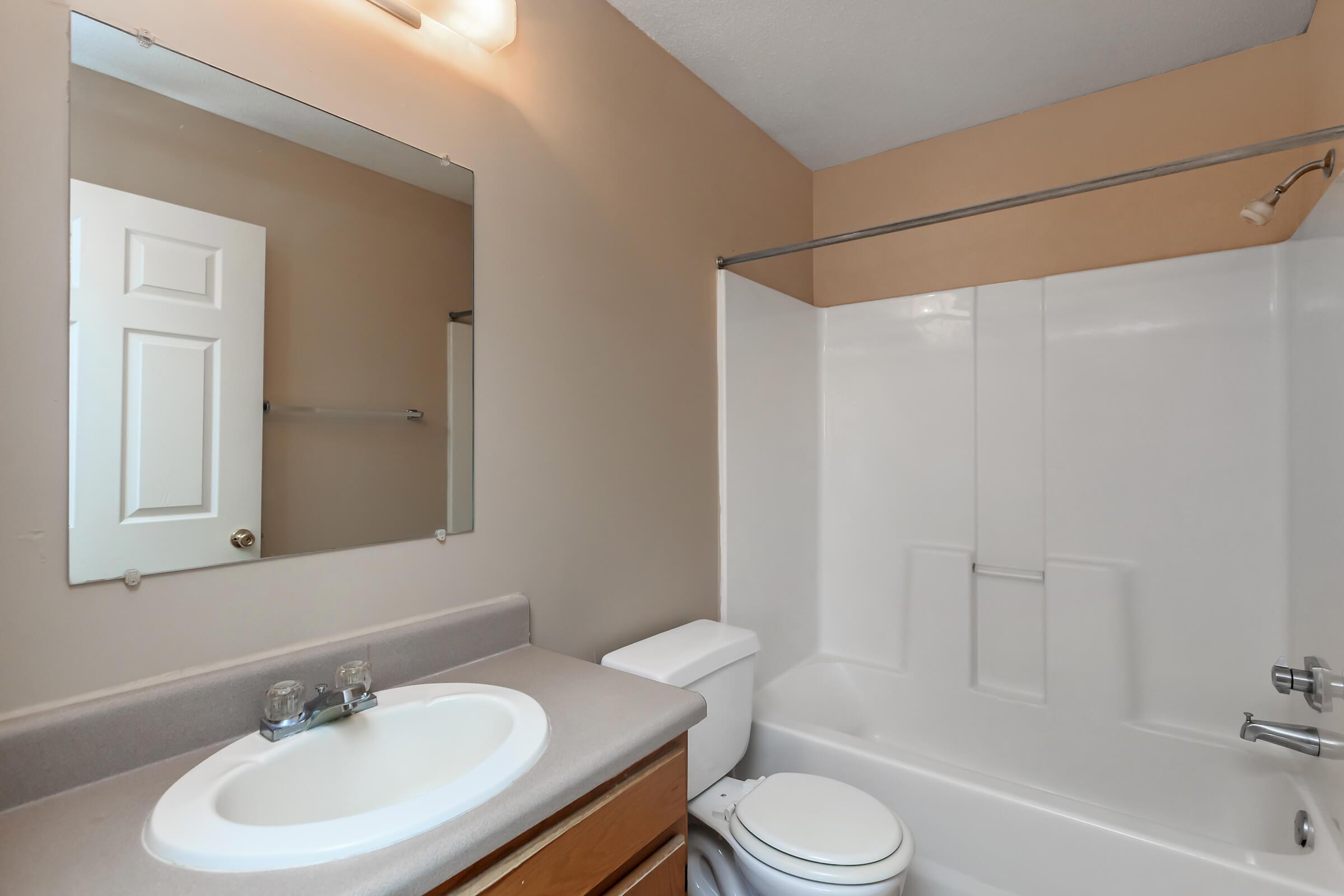 a white sink sitting under a mirror