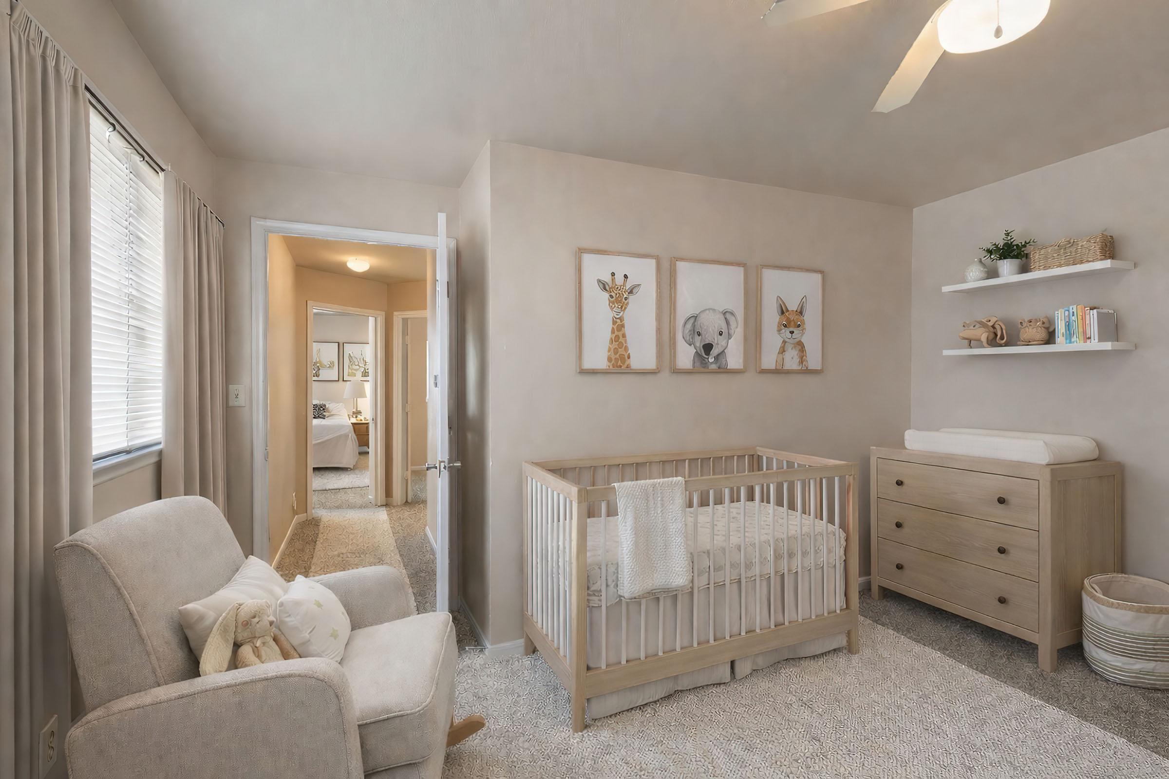 A cozy nursery featuring a light-colored crib, a changing table, and a comfortable armchair. The walls are adorned with animal-themed artwork, and there's a small shelf displaying decorative items. Natural light enters through the windows, creating a warm and inviting atmosphere.