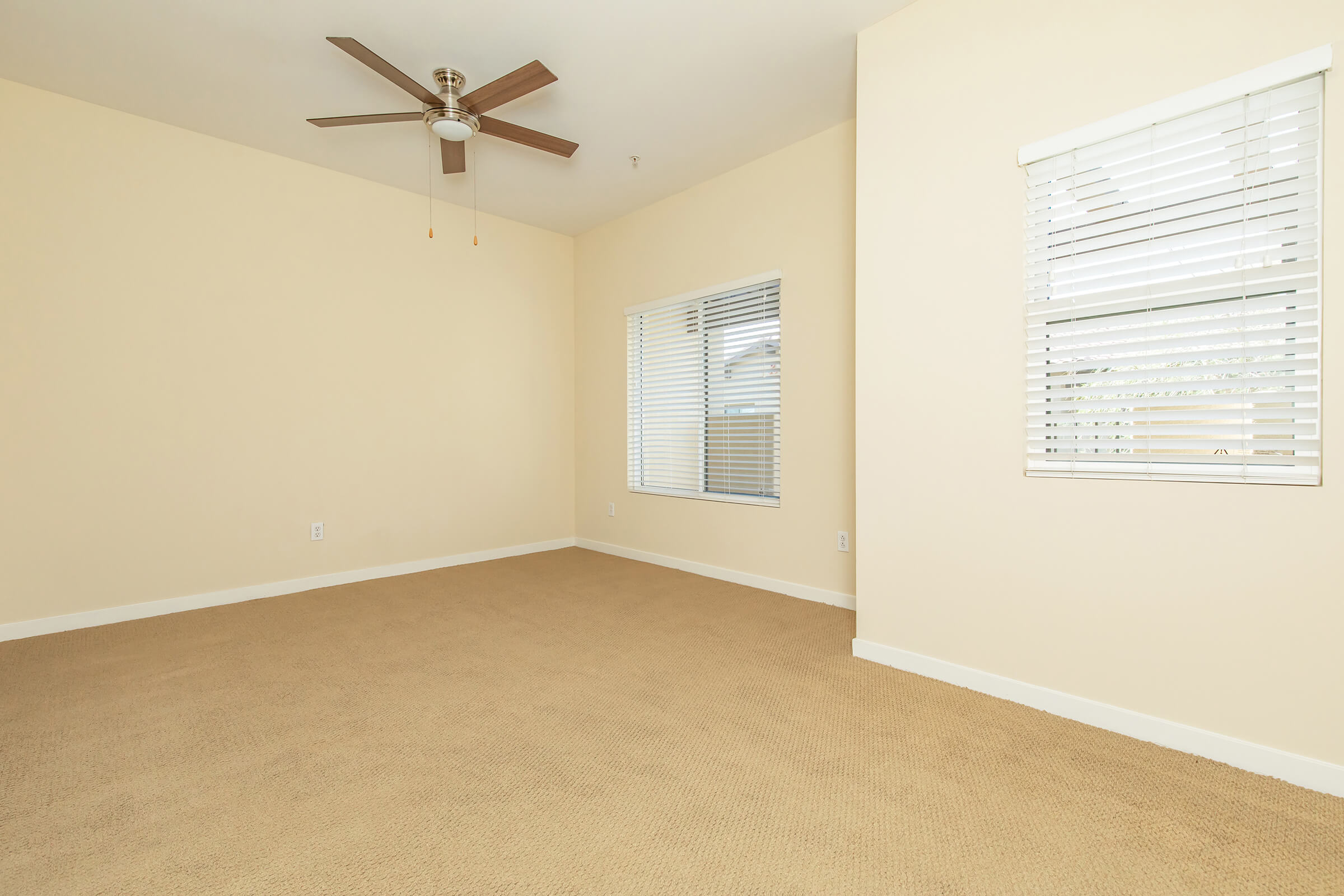 a room with carpet and a ceiling fan