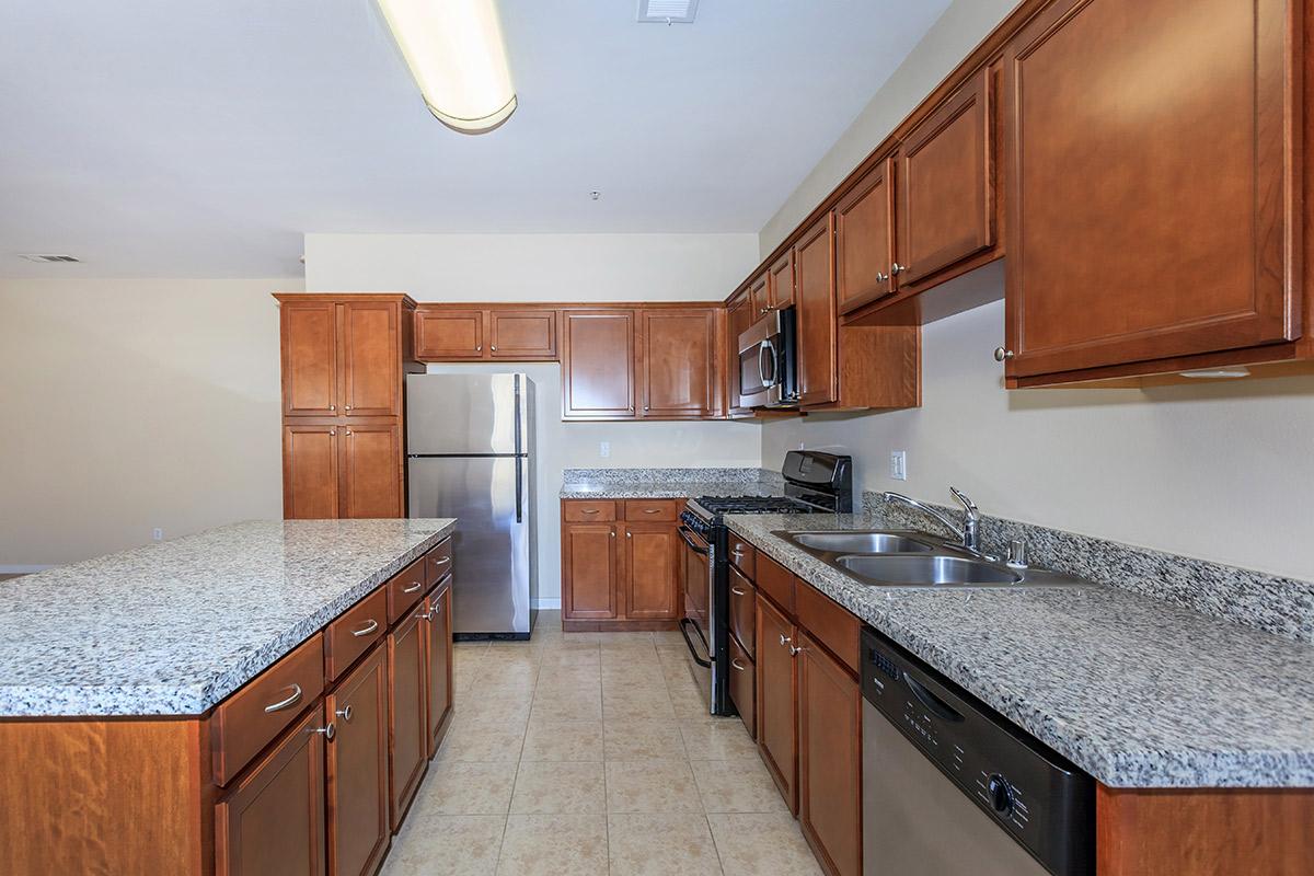 a large kitchen with stainless steel appliances and wooden cabinets