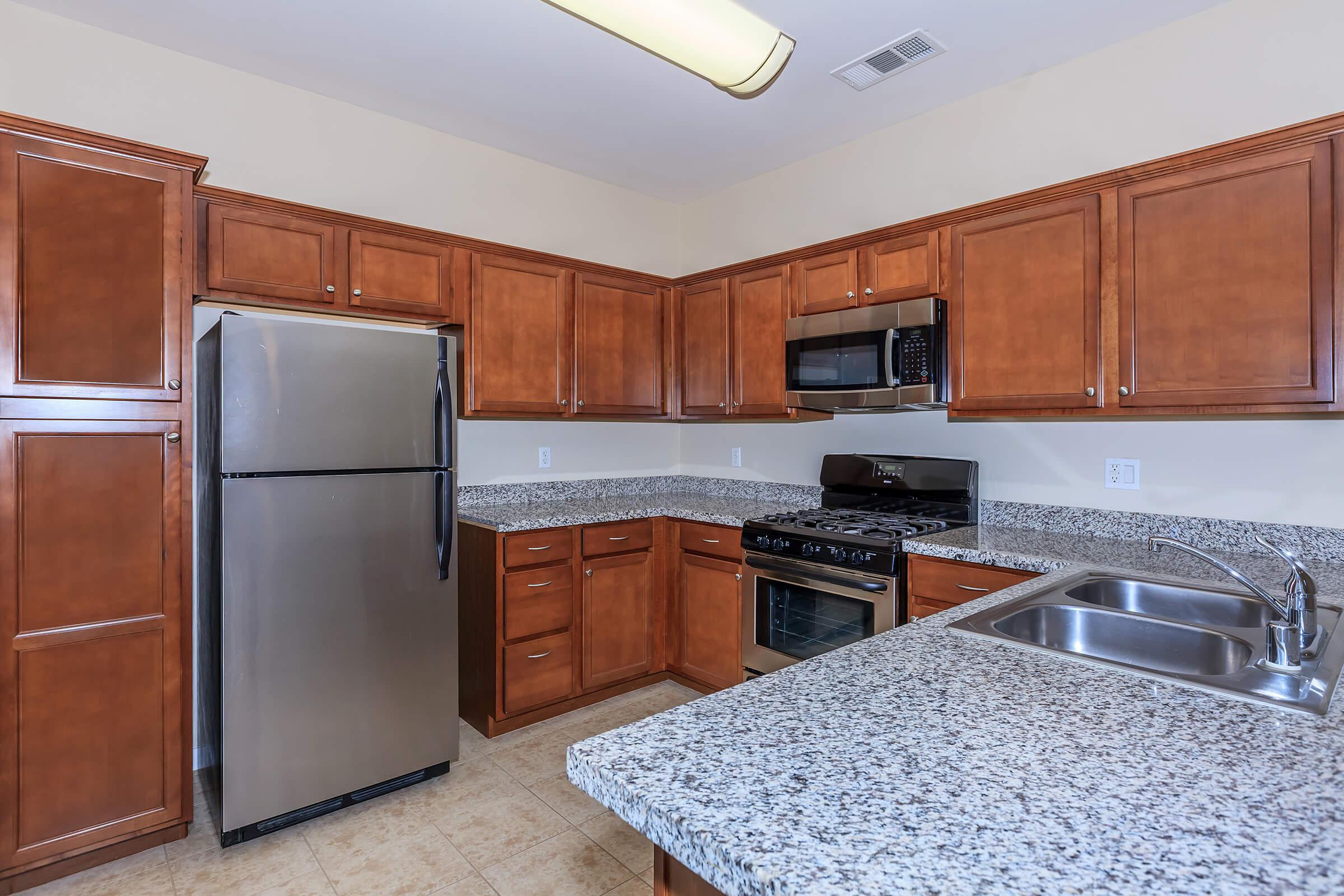 a large kitchen with stainless steel appliances and wooden cabinets