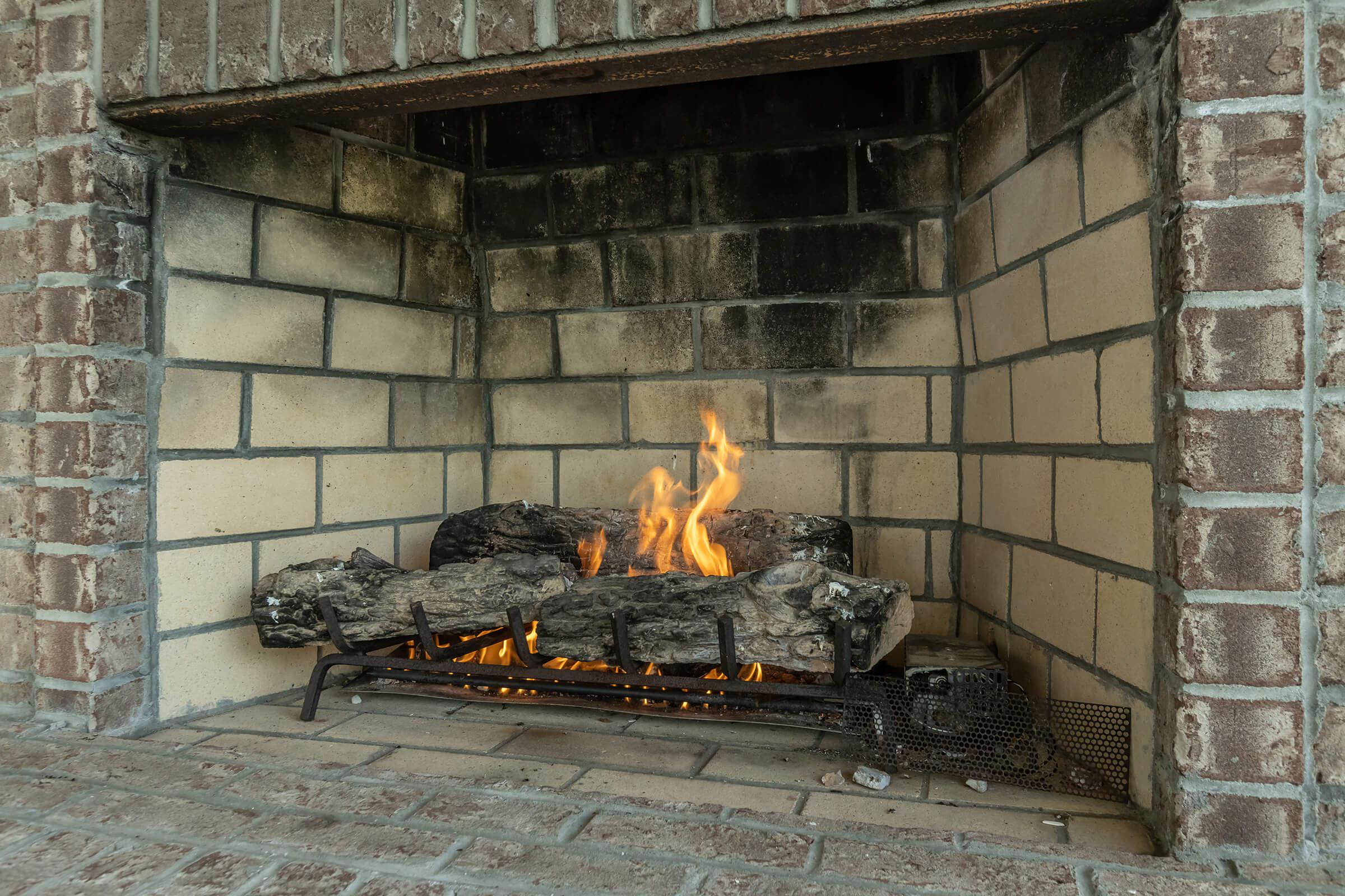 a stone fireplace in front of a brick building