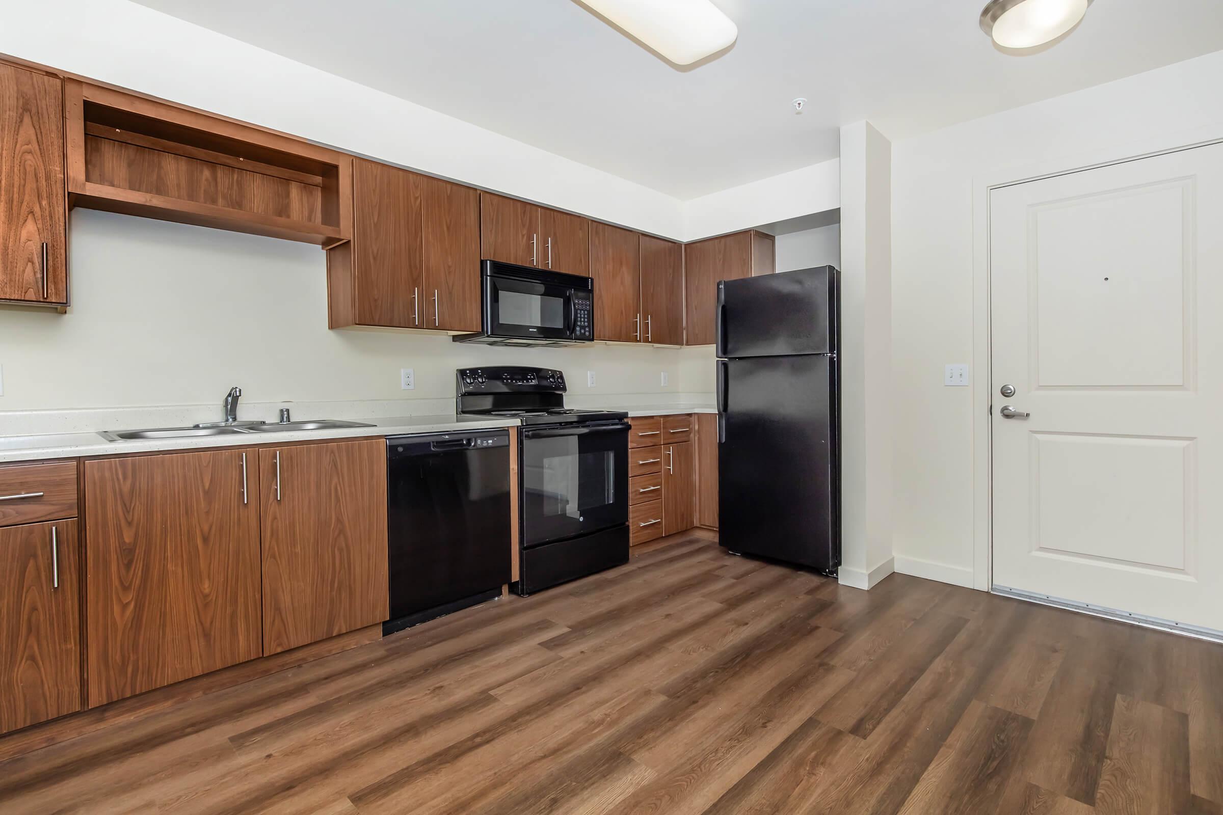 a modern kitchen with stainless steel appliances and wooden cabinets