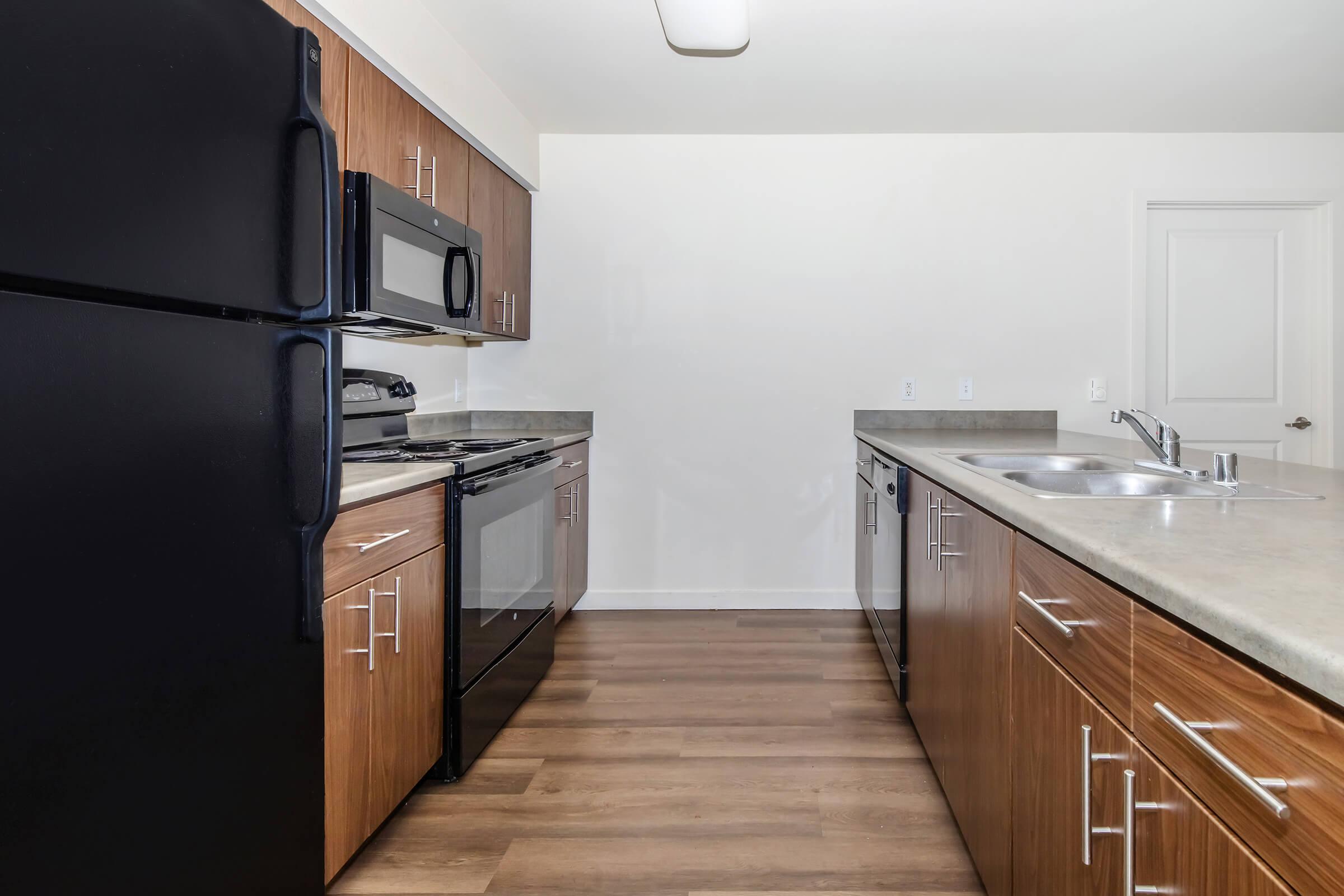 a large kitchen with stainless steel appliances and wooden cabinets