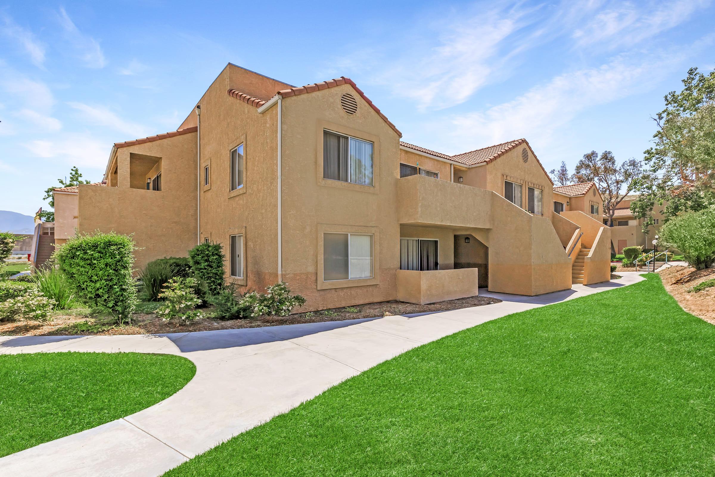 a large brick building with grass in front of a house