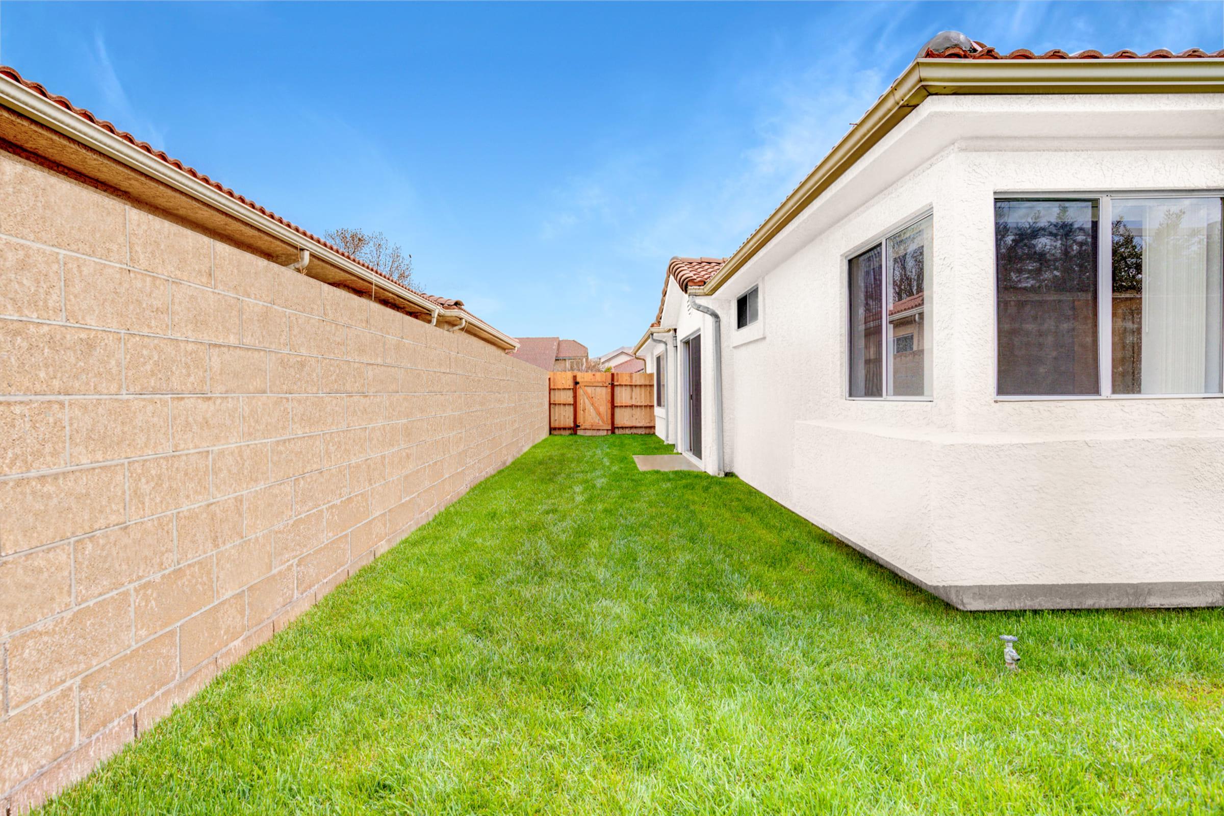 a large brick building with grass in front of a house