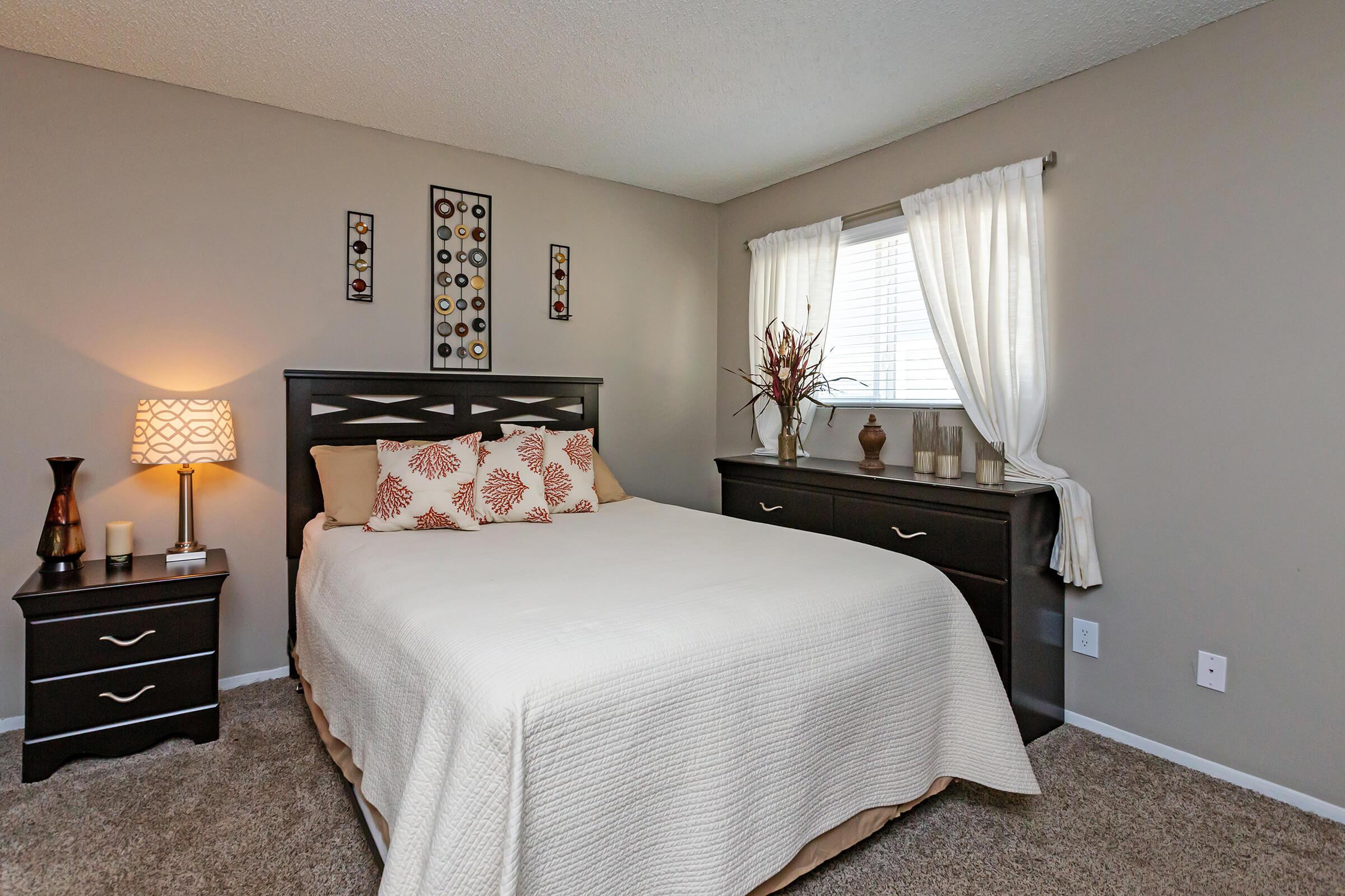 a bedroom with a bed and desk in a hotel room